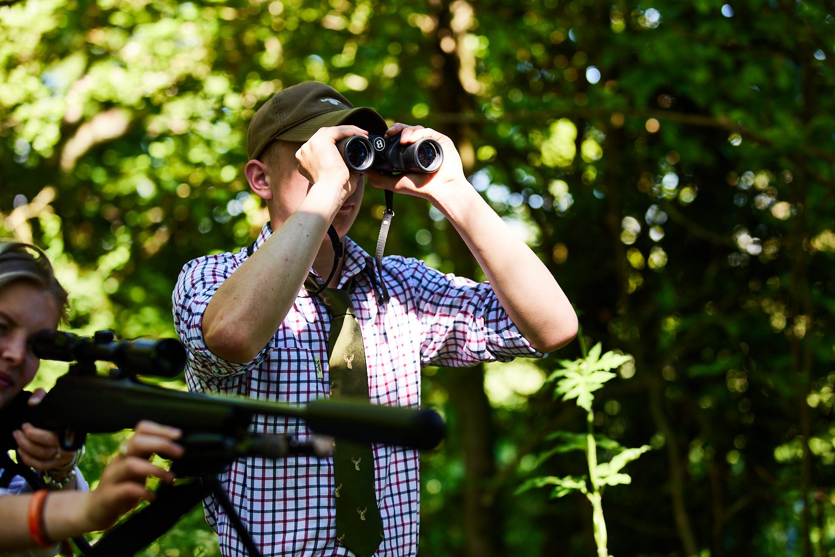 Wildlife student looks through binoculars