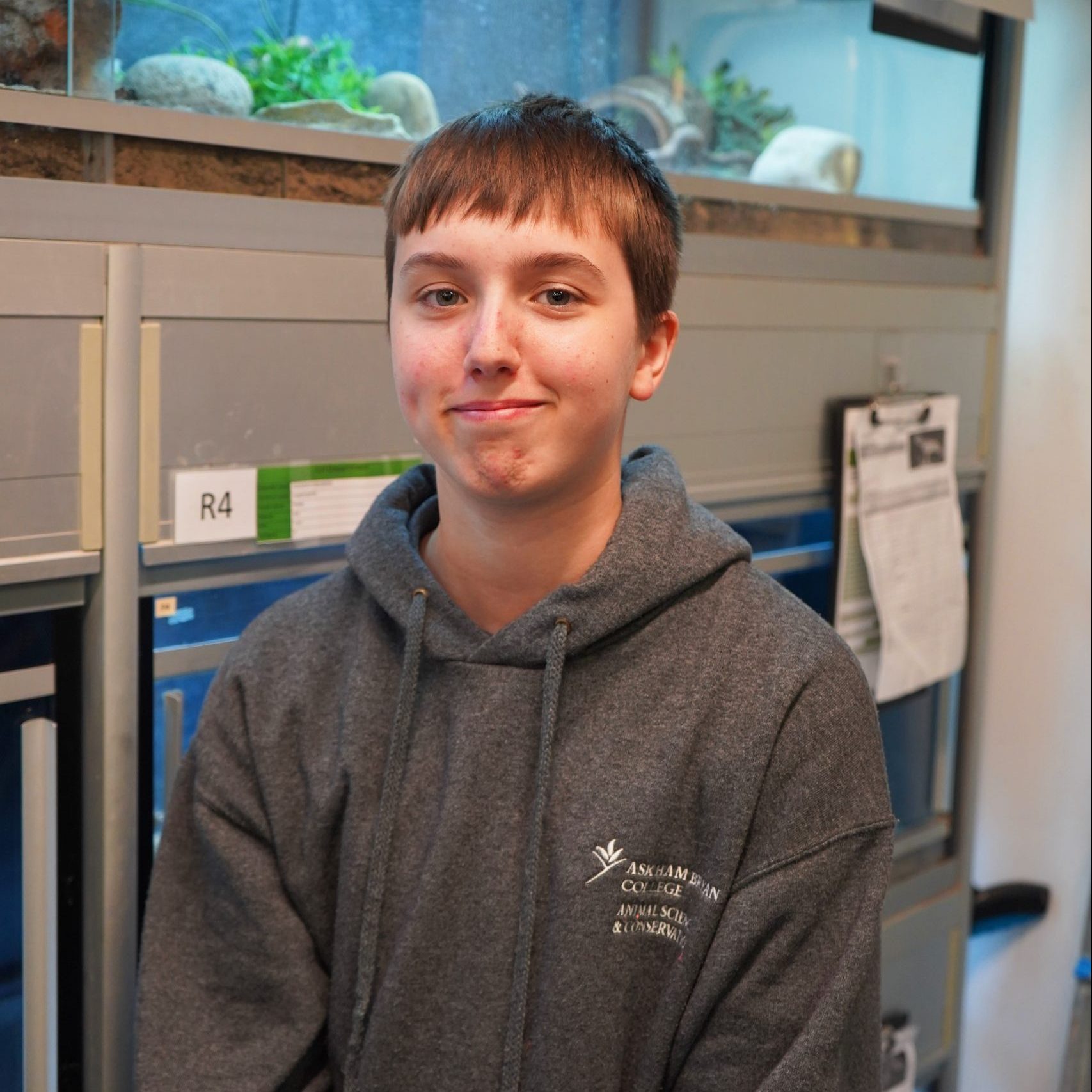 Image of a animal management student in front of a reptile enclosures