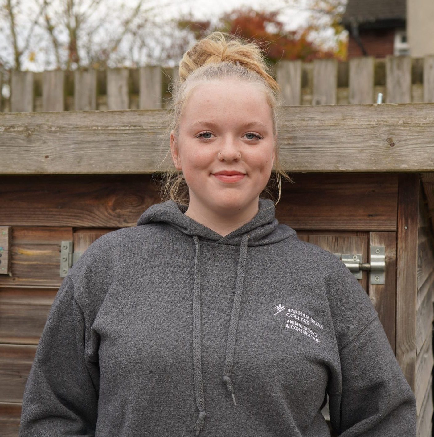Image of a animal management student in front of a rabbit enclosures