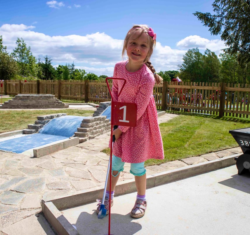 Child playing mini golf