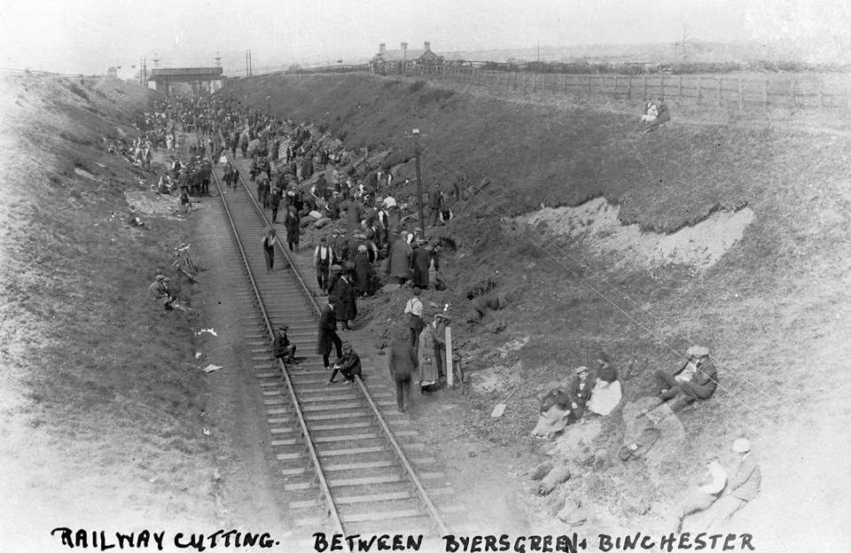 Figures on bank next to train track.