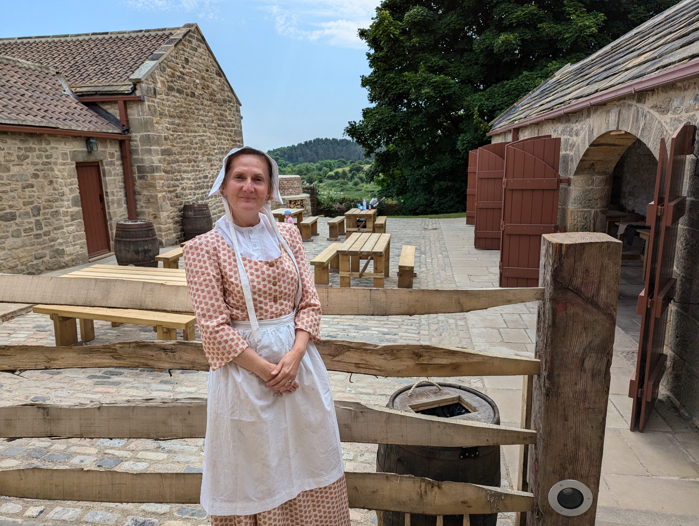 Figure in Georgian costume stood by the Tavern's outside seating.