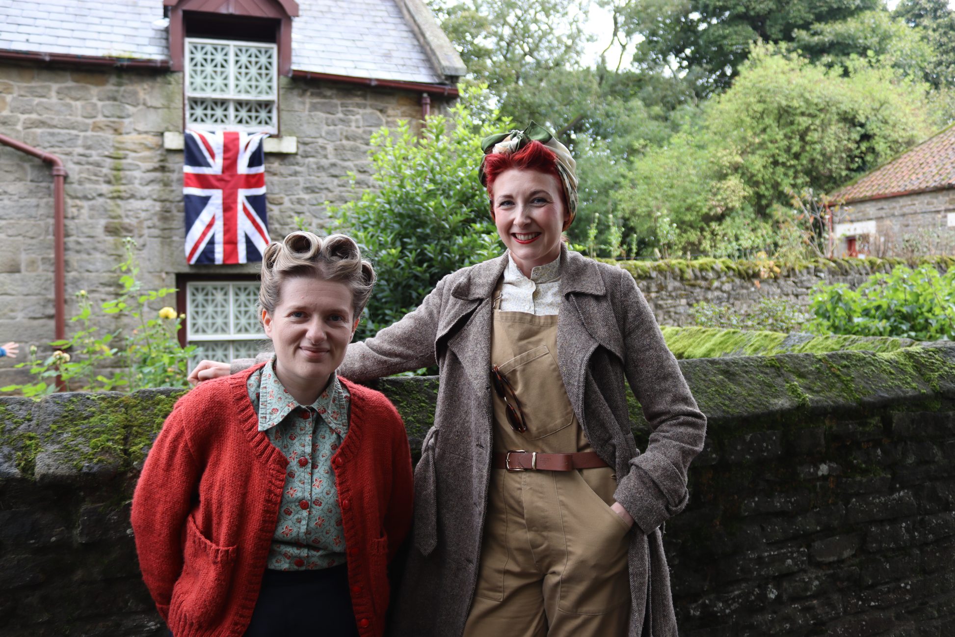 Two staff members dressed in 1940s costume.