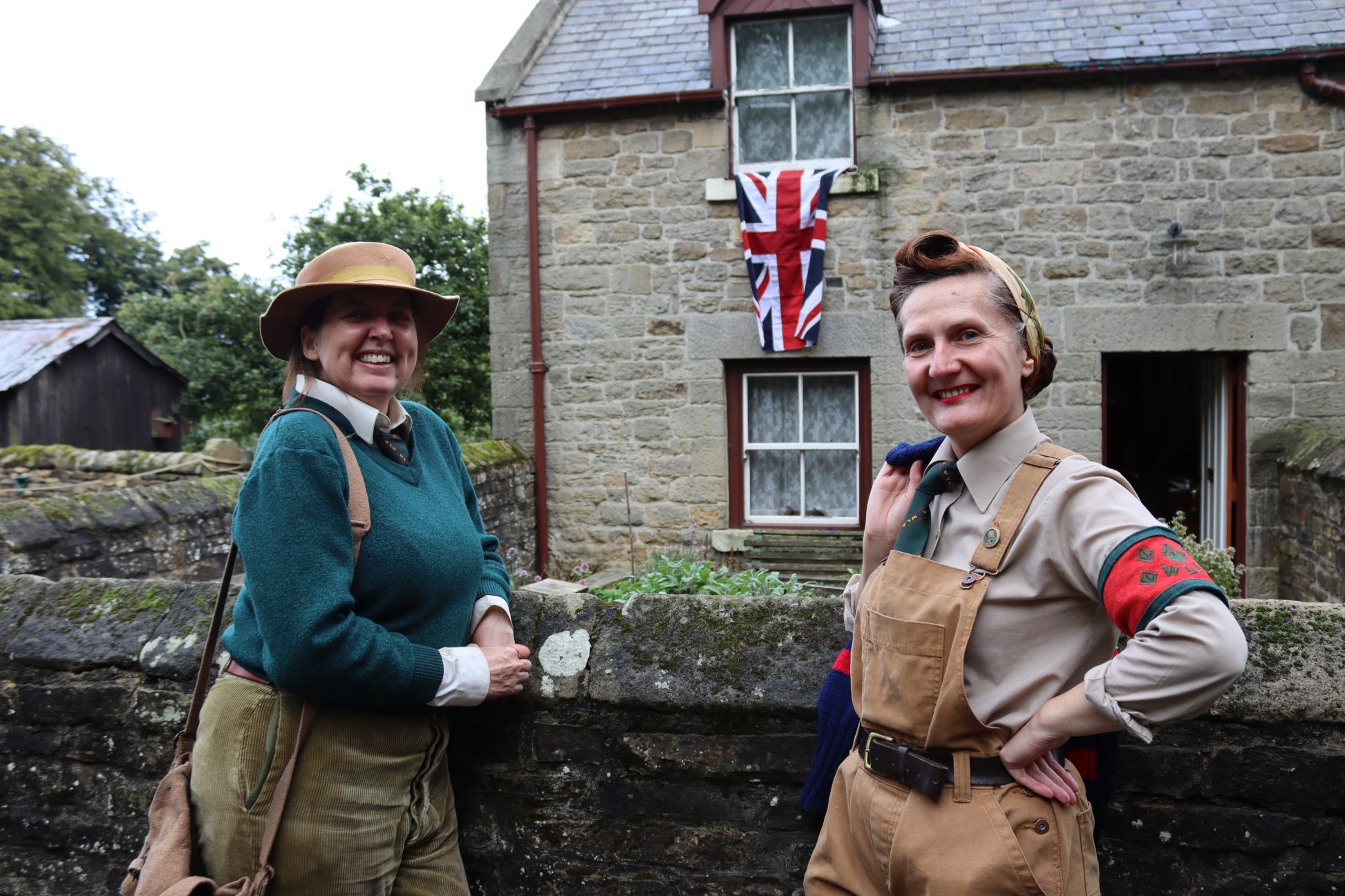 Two staff members in 1940s costume.