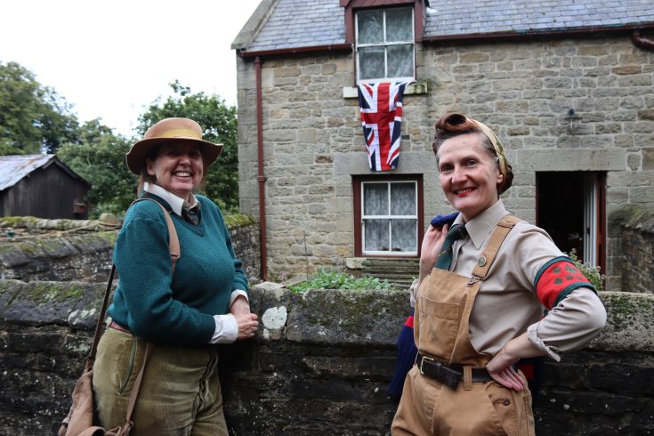 Two staff members in 1940s costume.