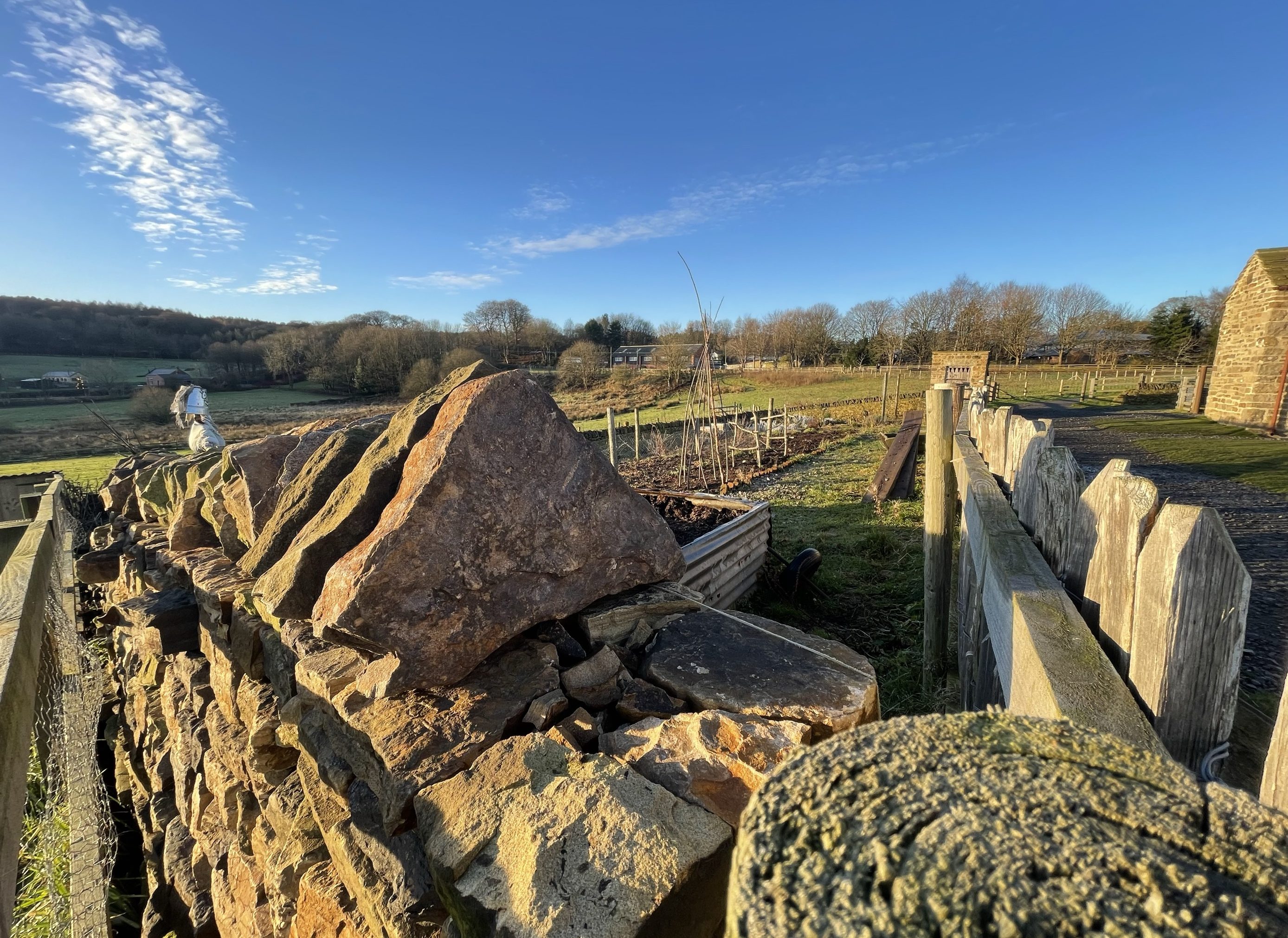 Landscape view with stone wall and fields.