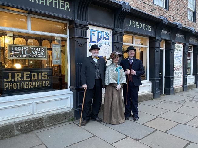 Three figures in Edwardian costume.