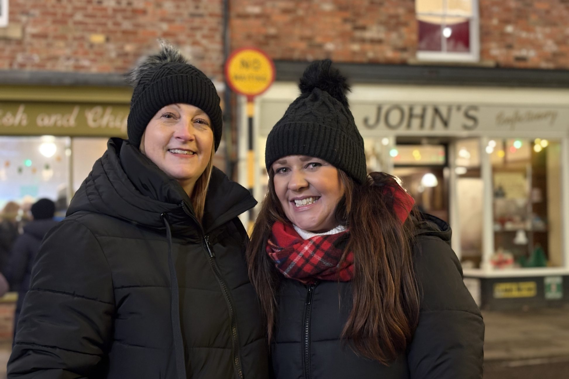 Two smiling visitors in the 1950s town.