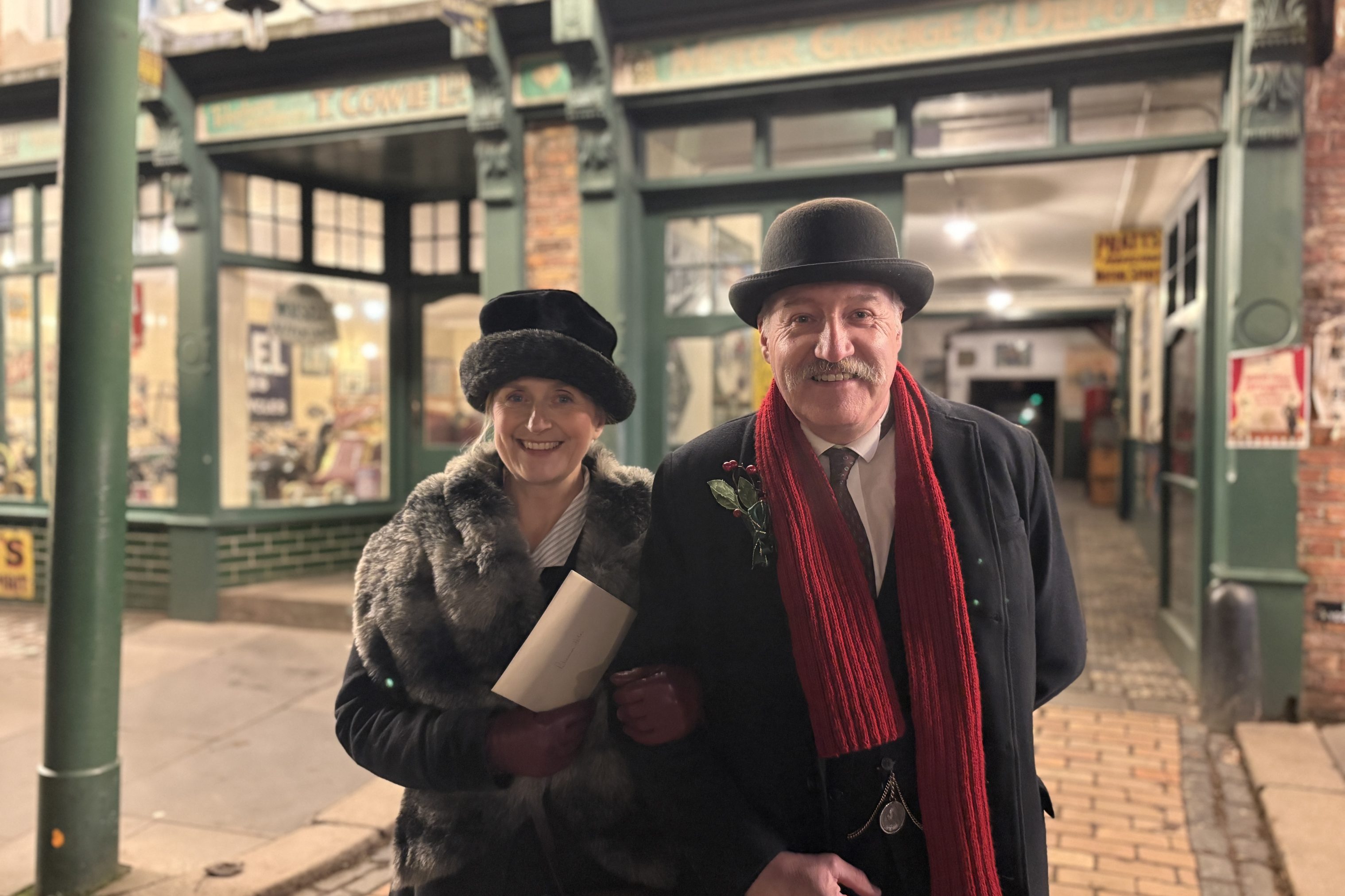 Two smiling staff members in front of the garage.
