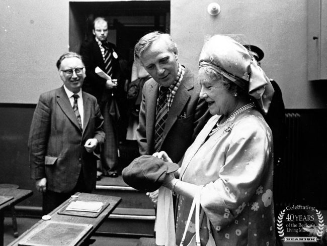 The queen mother talking with other figures.