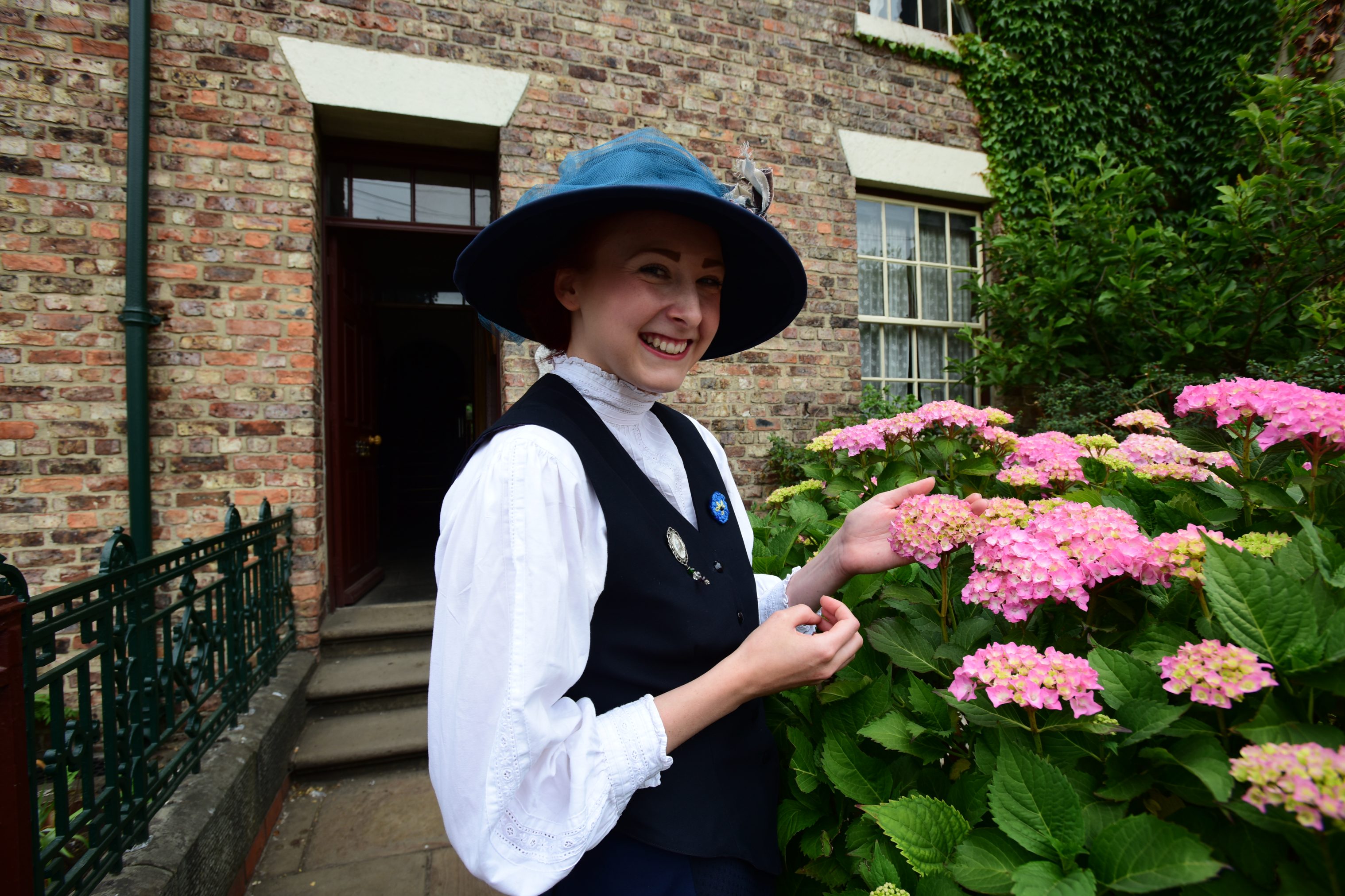 An Edwardian person in front of a home