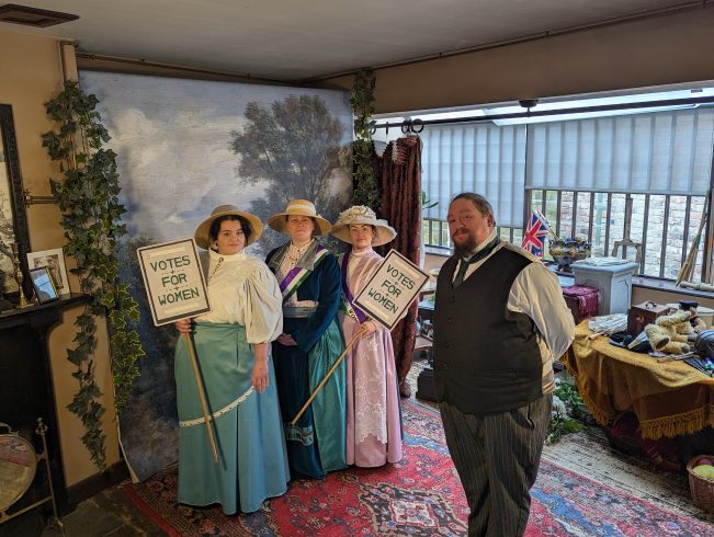 Figures dressed in Edwardian costume.