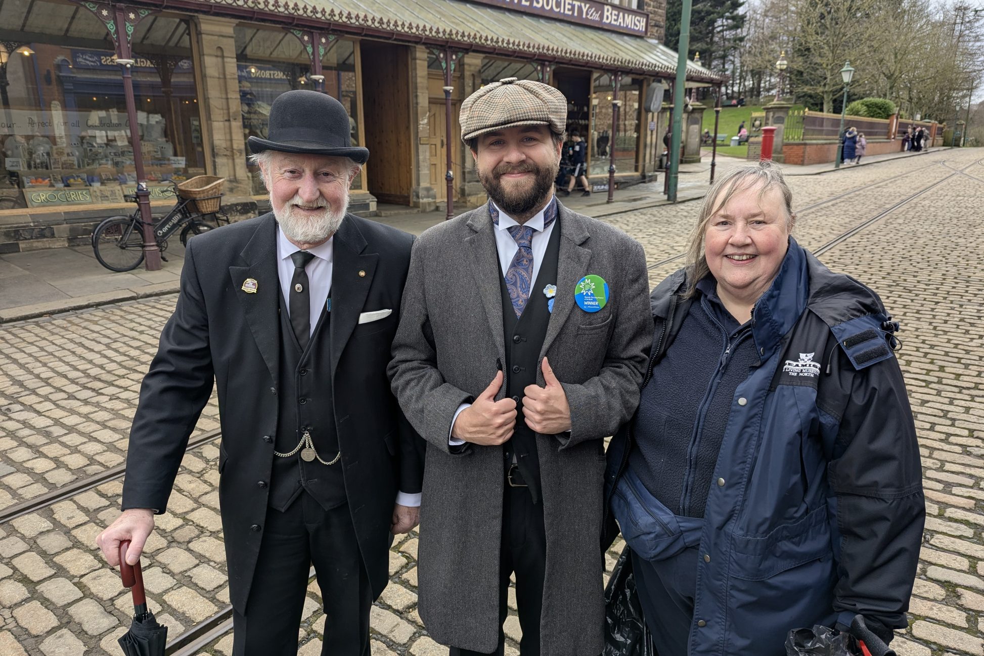 Three staff members on 1900s Town street
