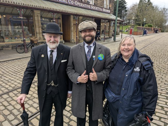 Three staff members on 1900s Town street