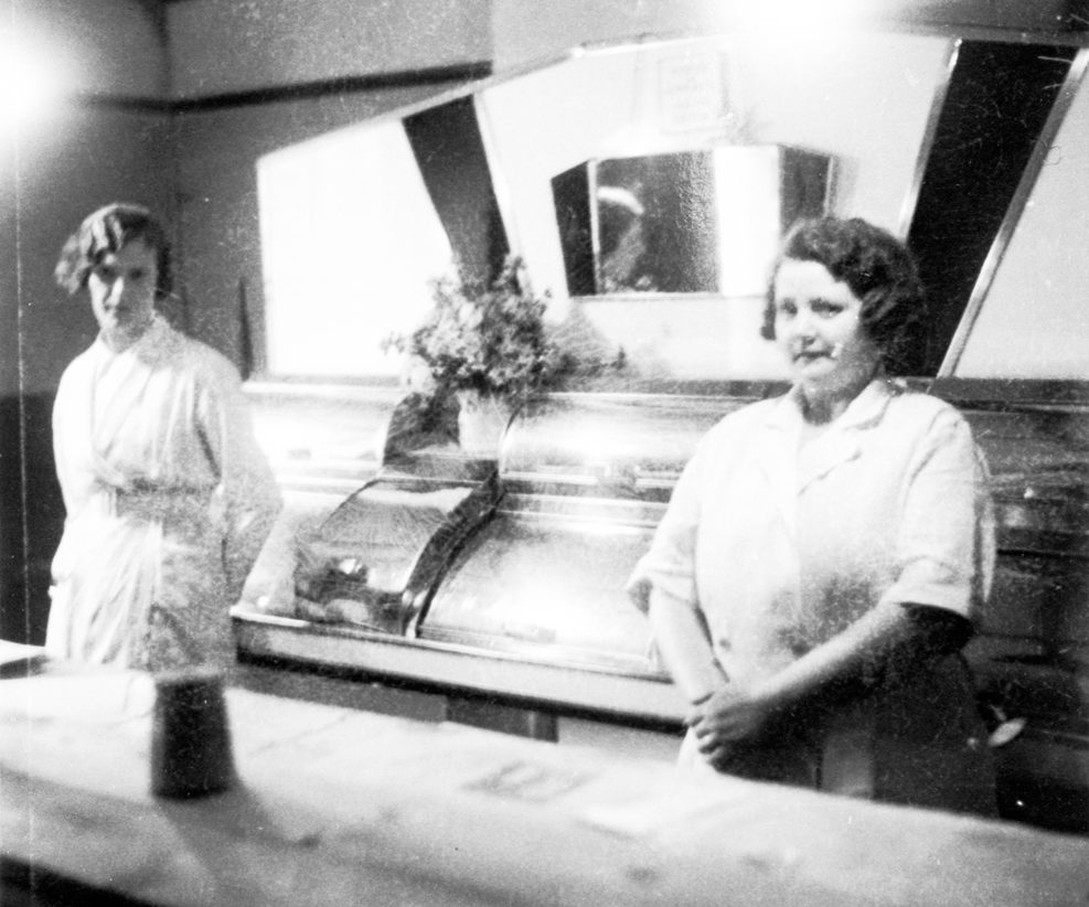 Two figures stood in front of chip fryer.