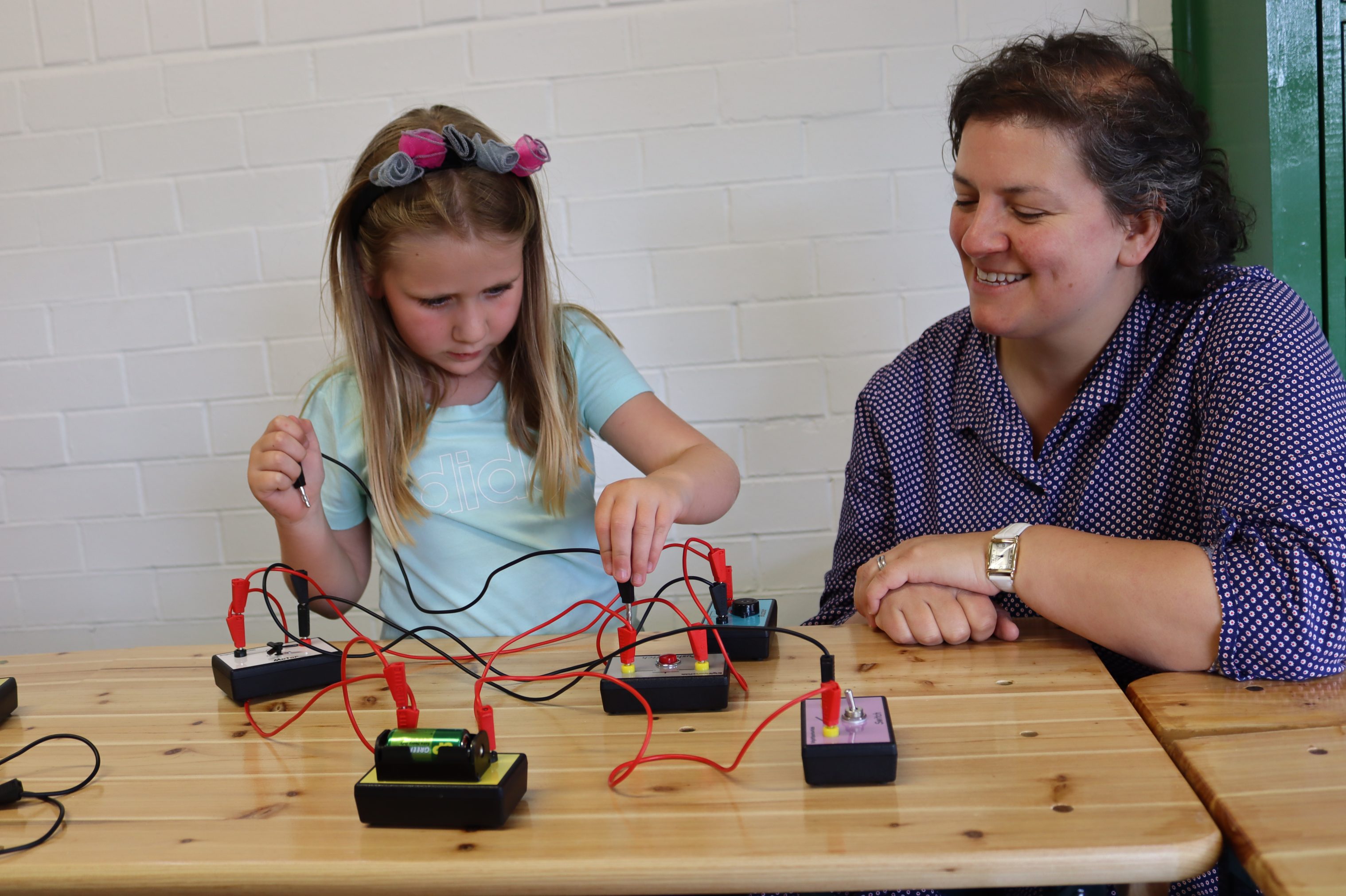 Adult and child with wires and switches.