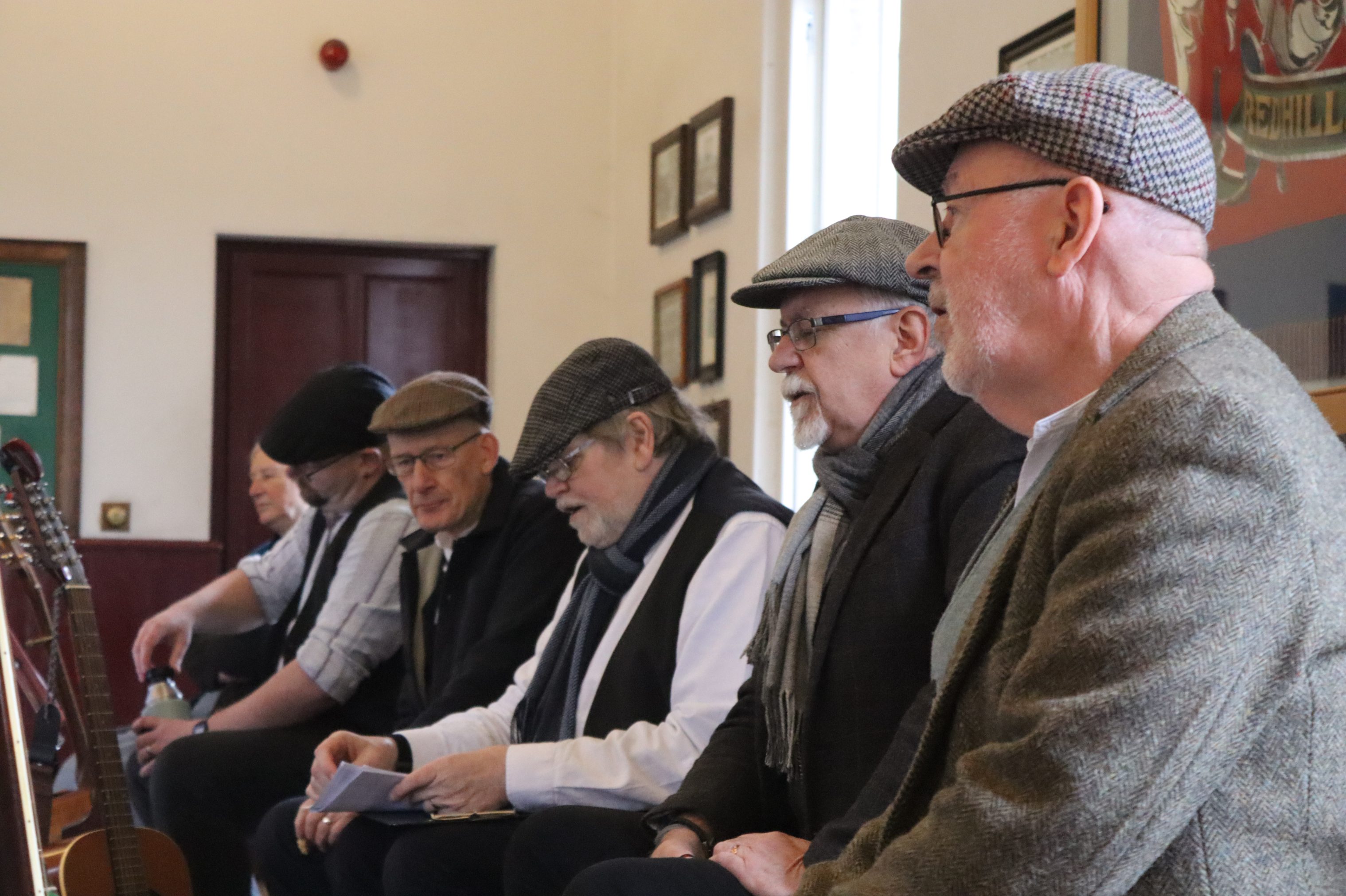 Collection of flat capped figures singing