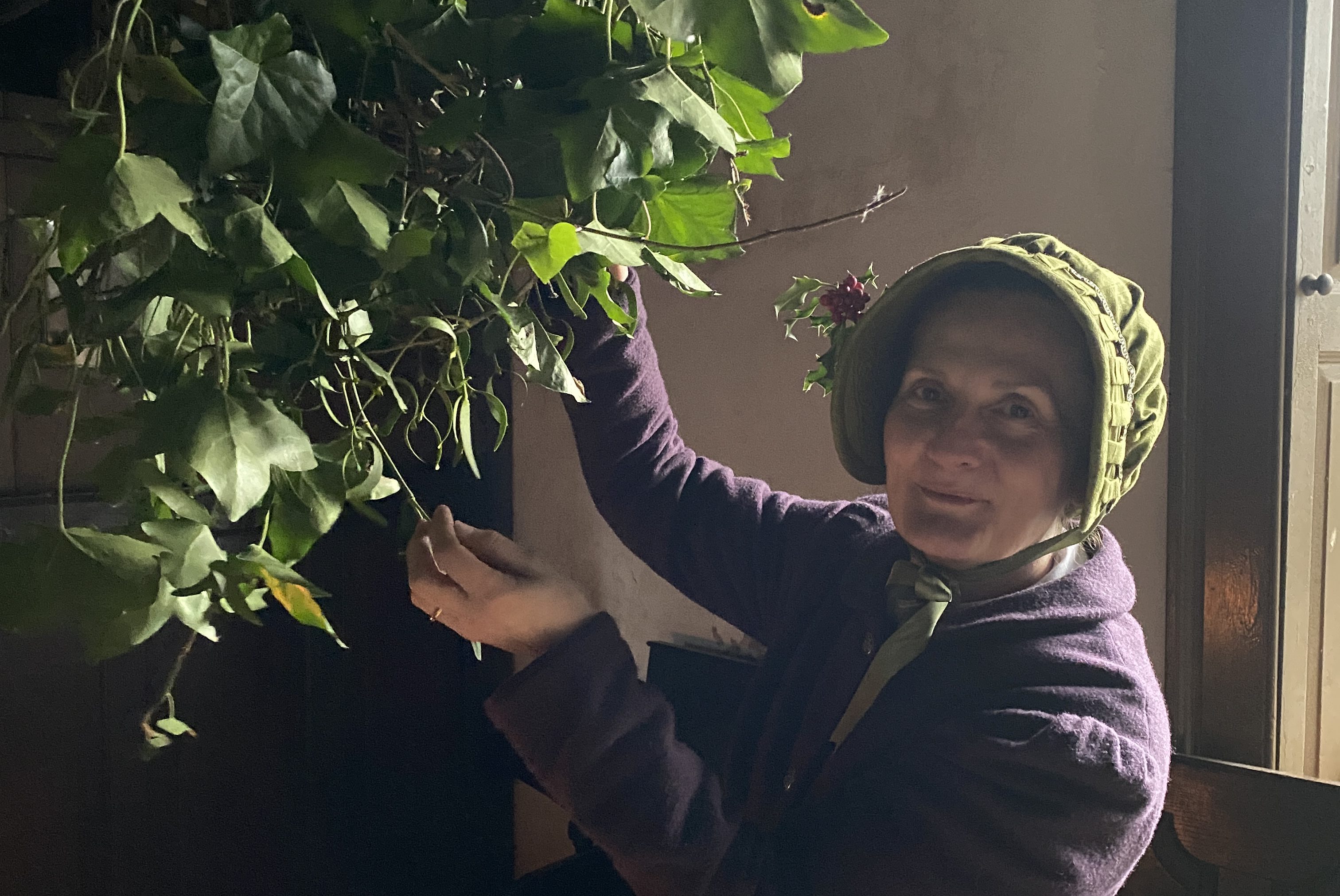 Costumed engager with traditional leafy christmas decorations.