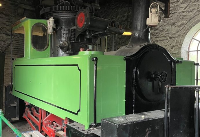 Green locomotive in shed.