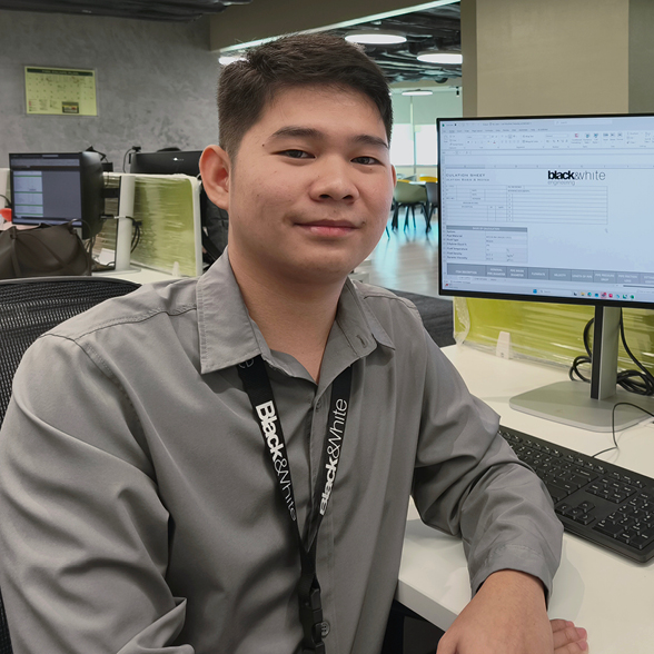 Ziddeny a graduate mechanical engineer at Black & White sat at his desk smiling in the Manila office