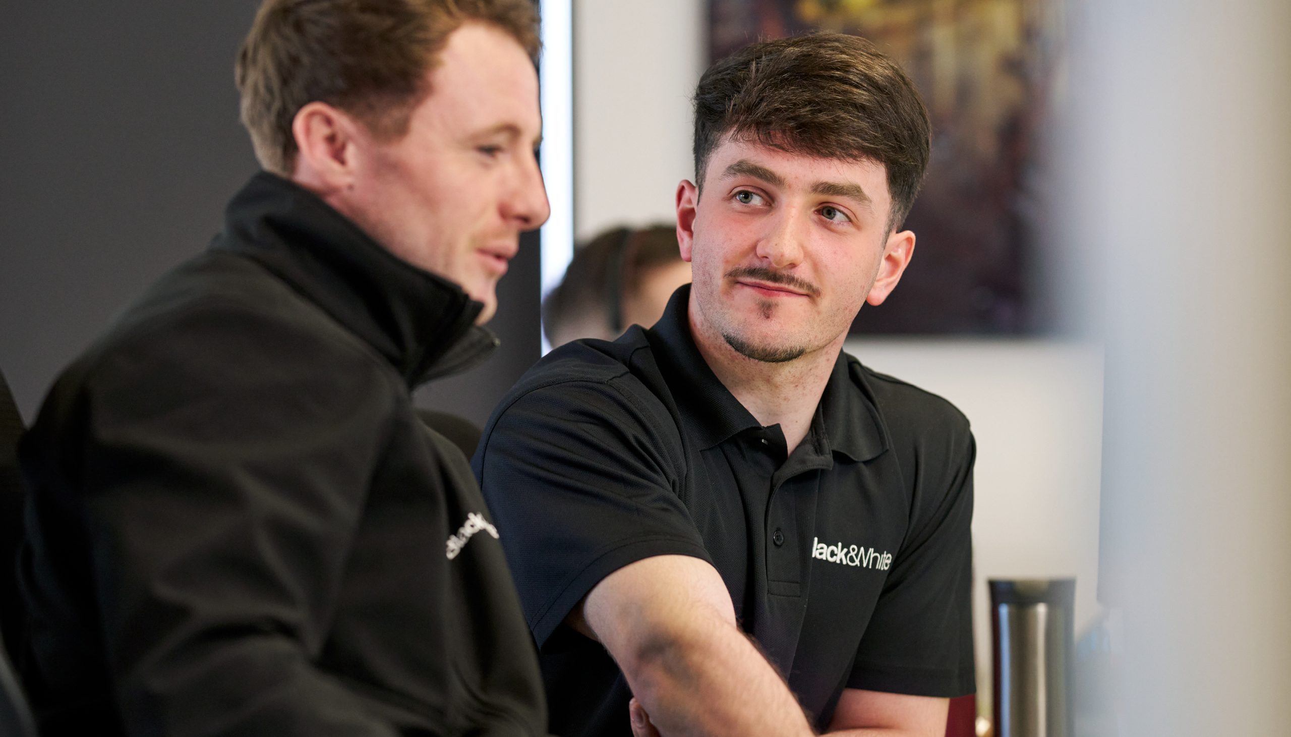 A Black & White Apprentice Elliot being mentored by another engineer.