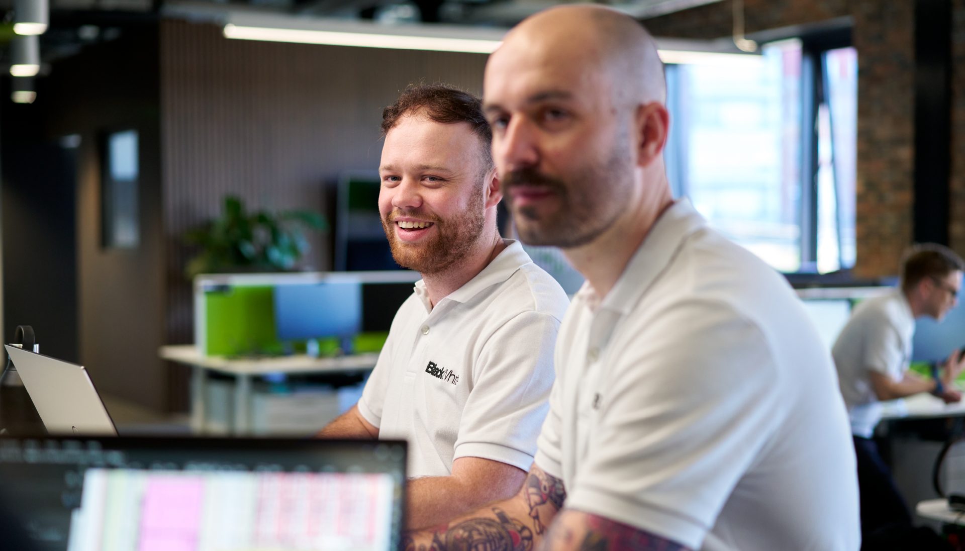 Two male engineers featured in a team meeting in an office environment