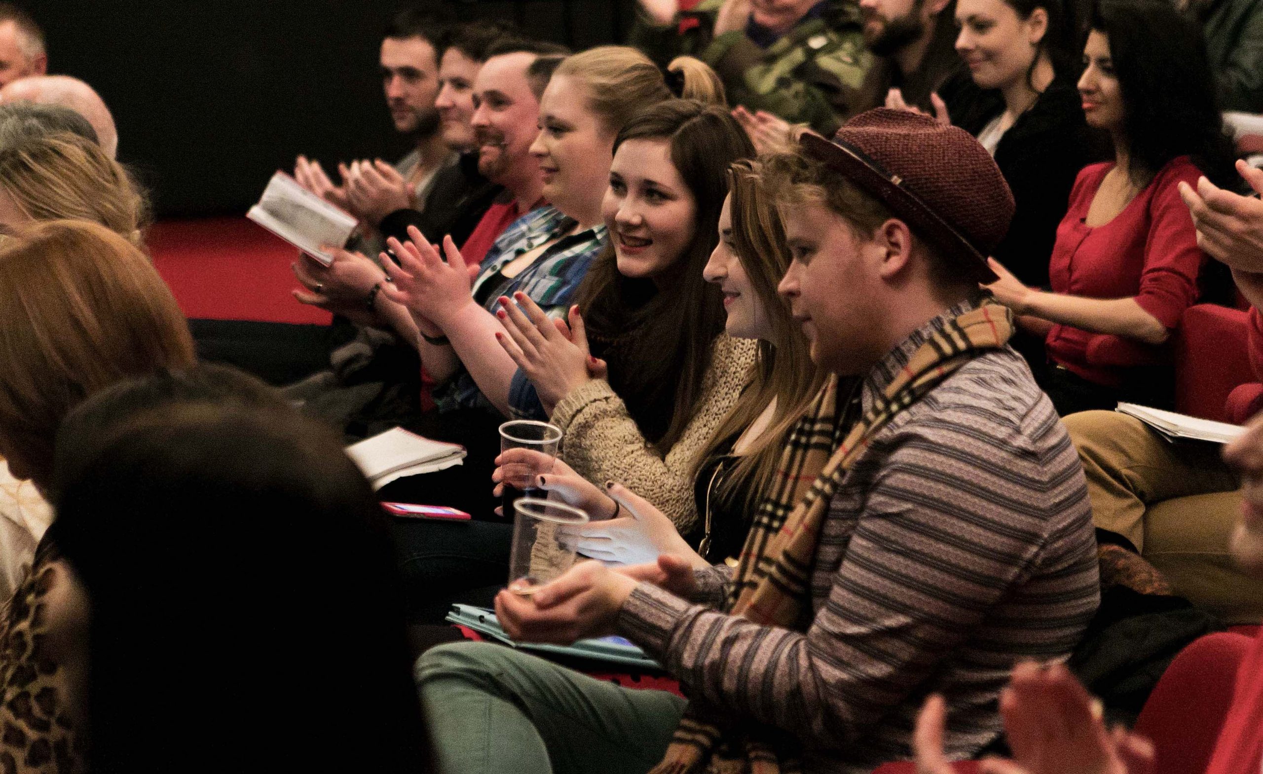 GFT Education Team: BFI Film Academy Recommends Screenings for young people. A film audience of young people sit clapping and smiling.