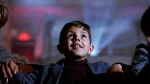 A young boy watches a cinema screen in awe. Cinema Paradiso still.