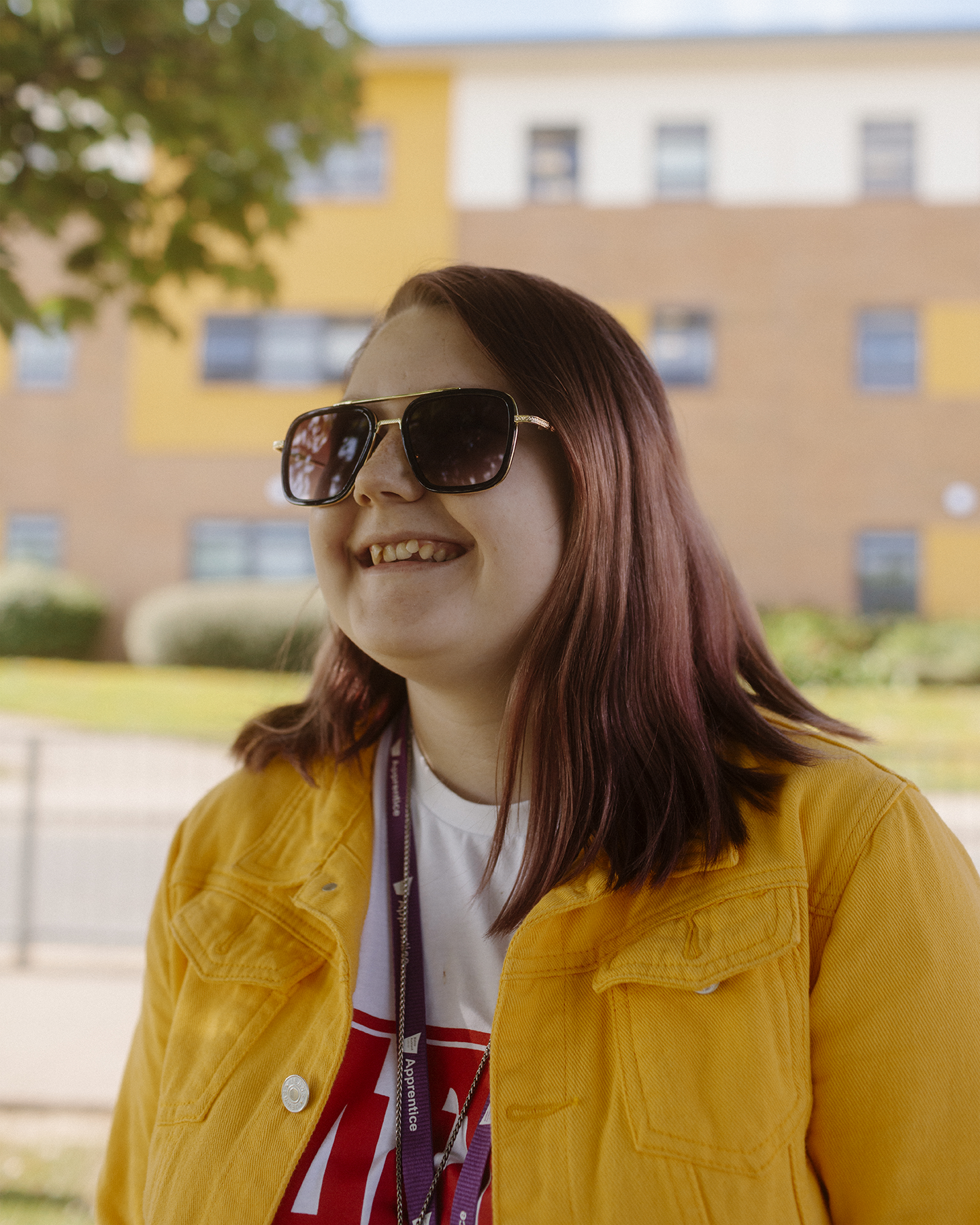 Portrait of female student wearing sunglasses outside a technical college in Bishop Auckland.