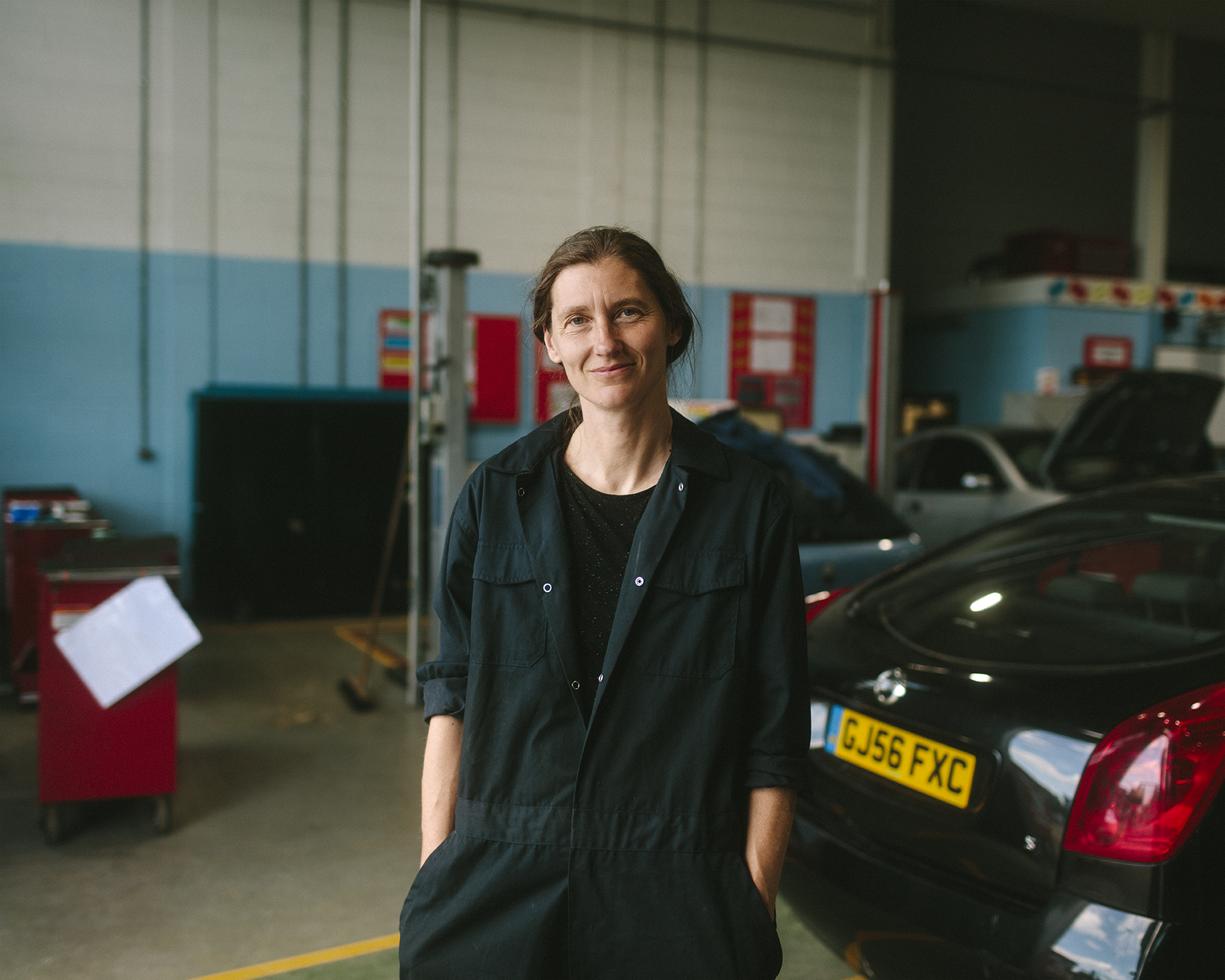 Portrait of female mechanic in garage environment.