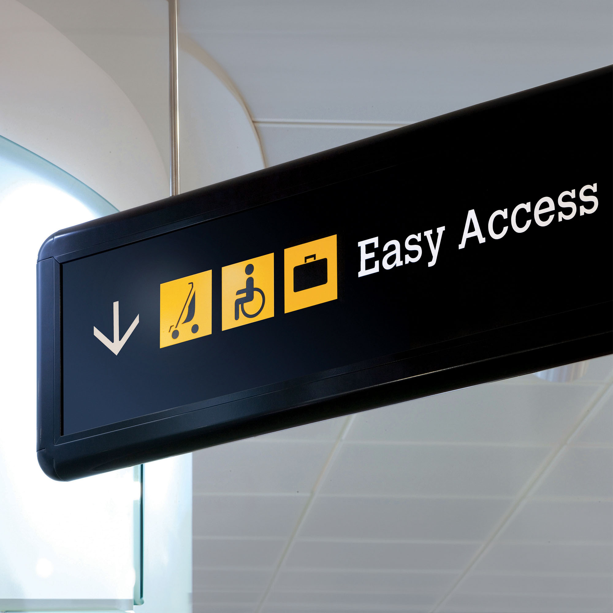 Black directional sign showing the iconogrpahy system which was created for Metro as part of the rebrand. The sign is black on with yellow icons and white information.