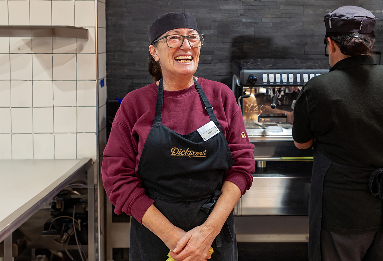 A woman smiling at work in a shop