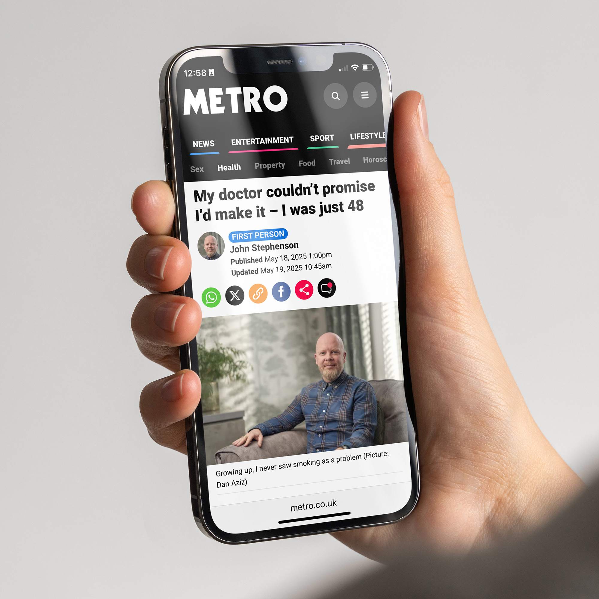 A hand holding a phone showing a news article