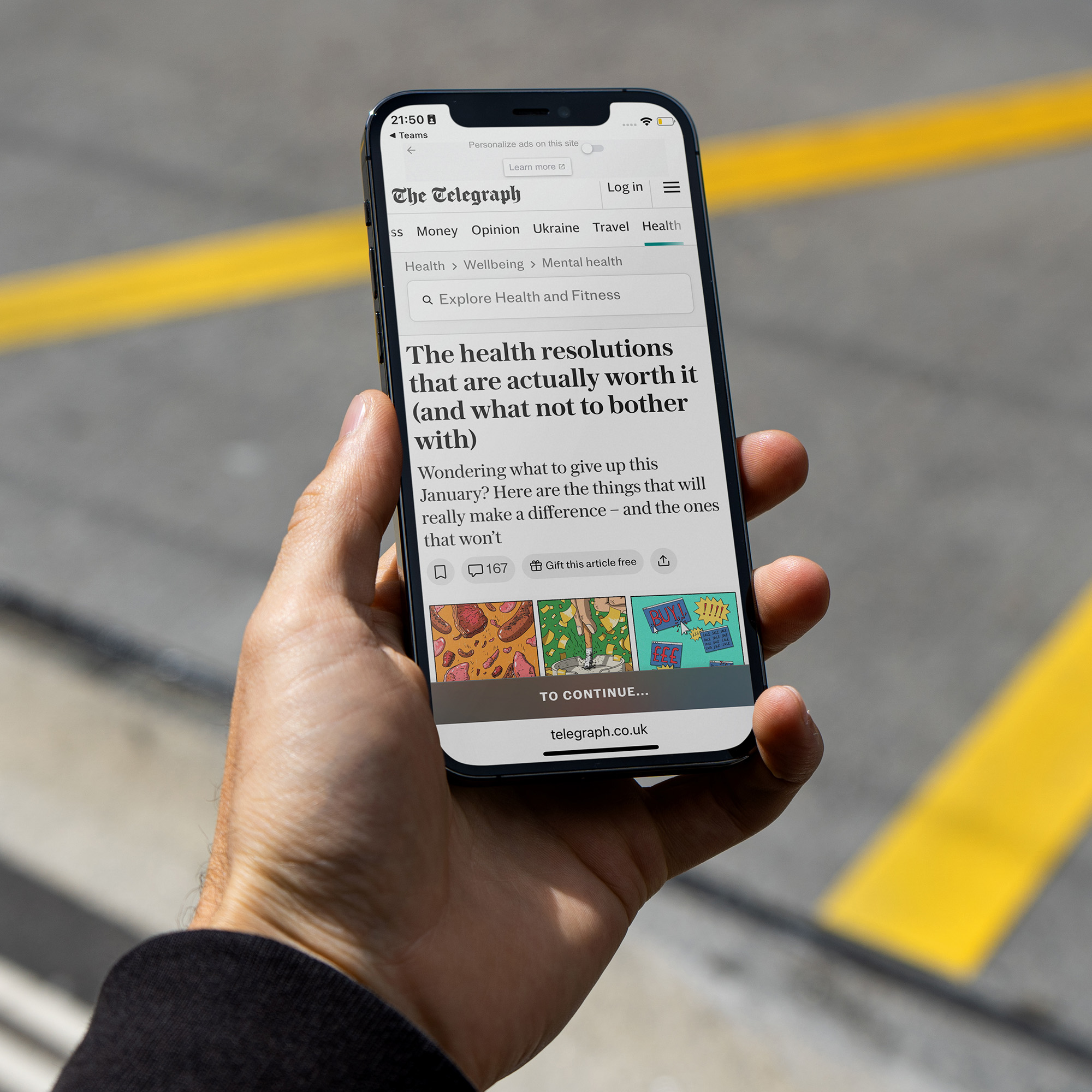 A hand holding a phone showing a news article