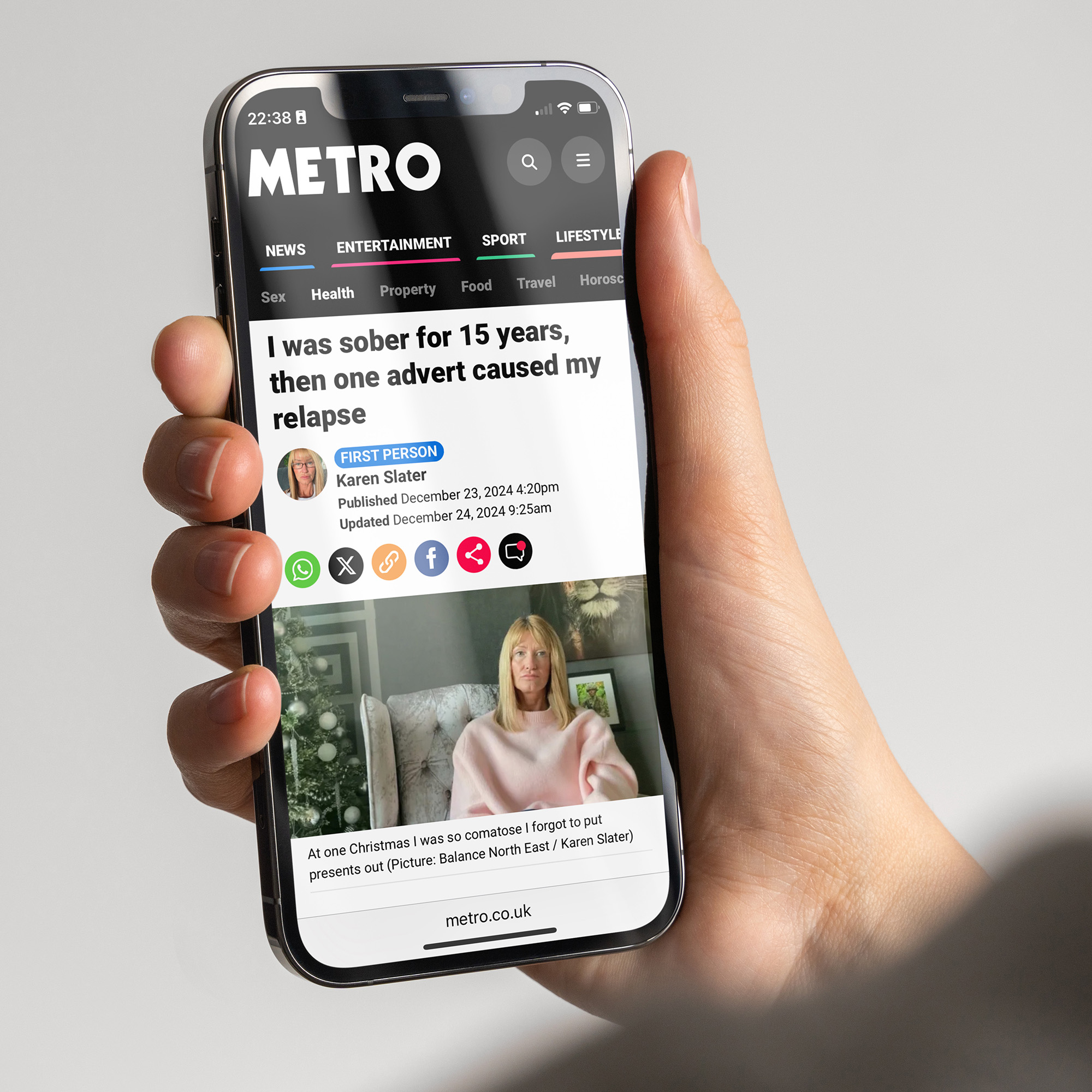 A hand holding a phone showing a news article