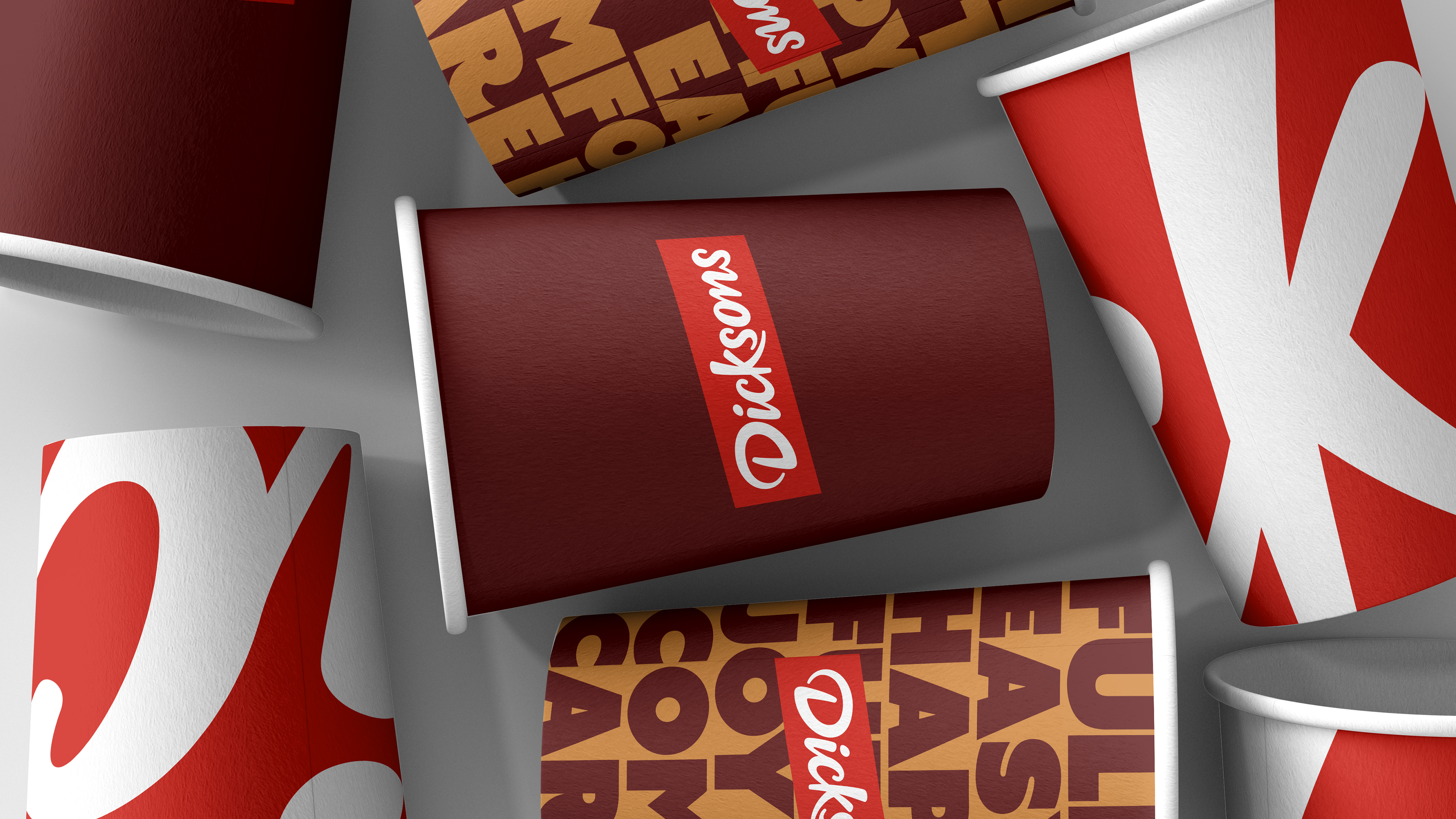 A cup is positioned sideways and has the word Dicksons in the middle.