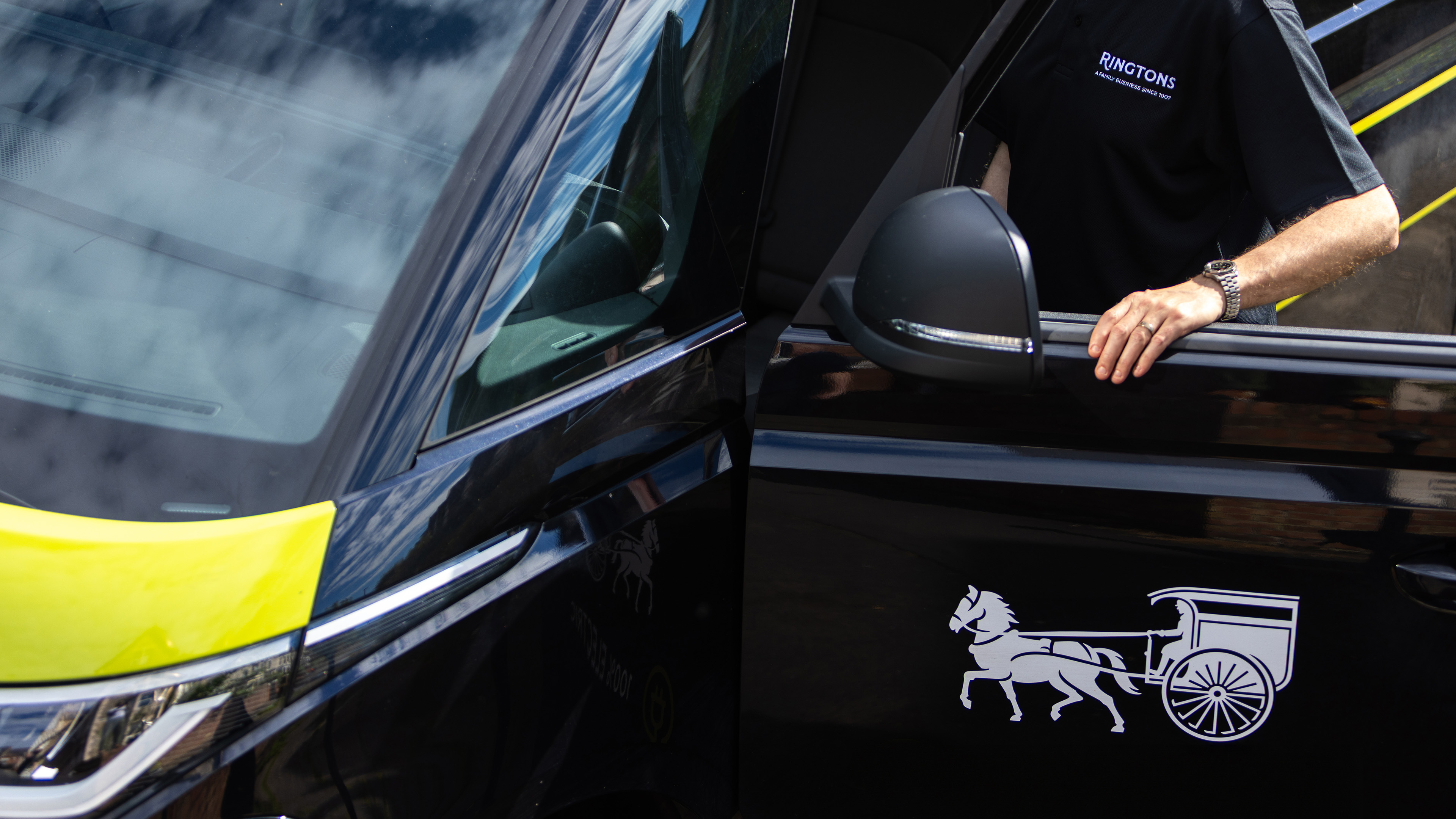 Man opens black car door.