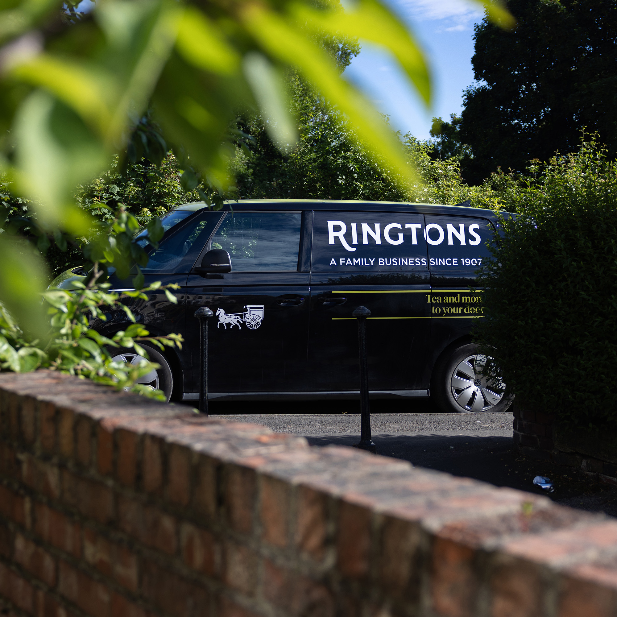 Delivery fan parked on street during sunny day.