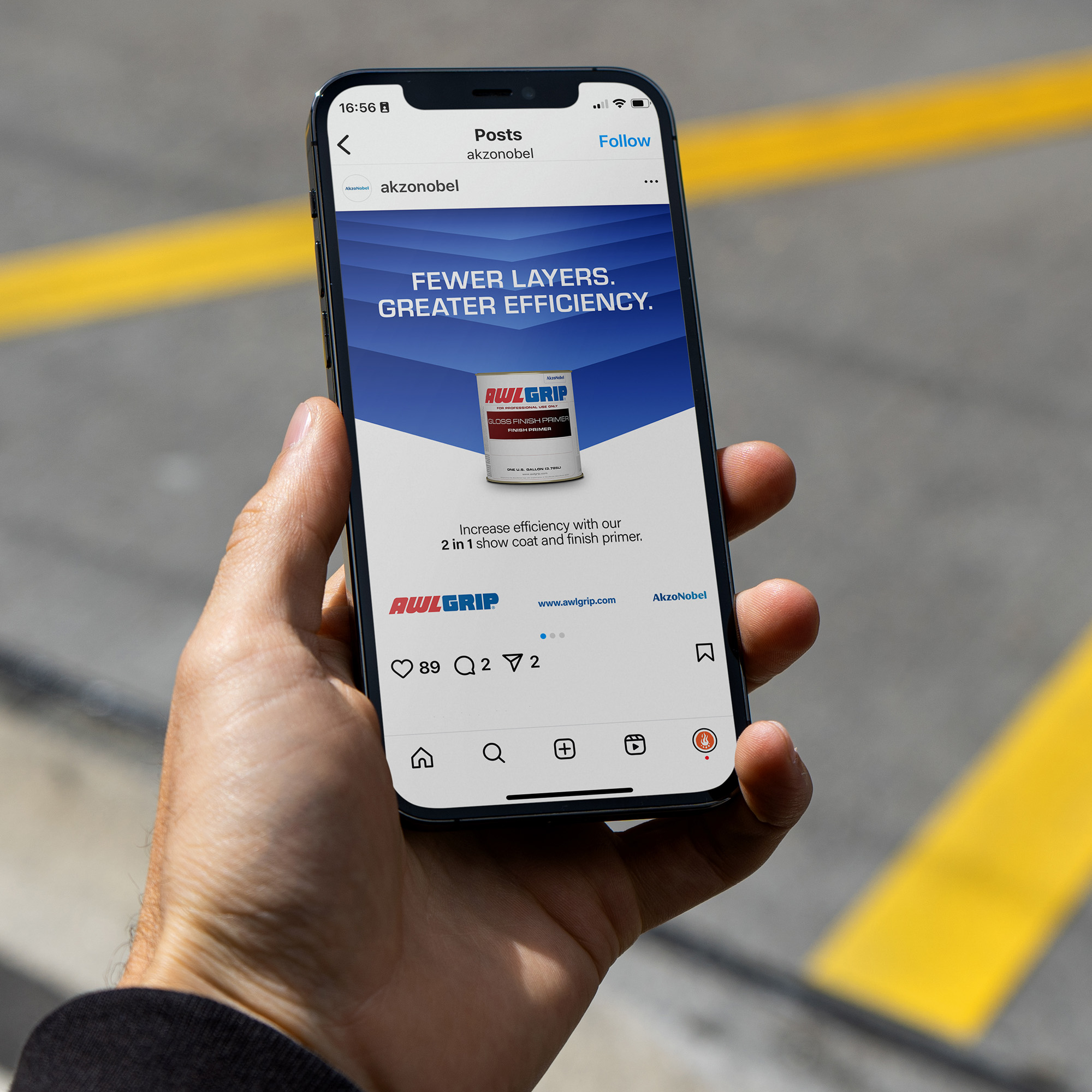 A hand holding a phone showing a blue and white graphic