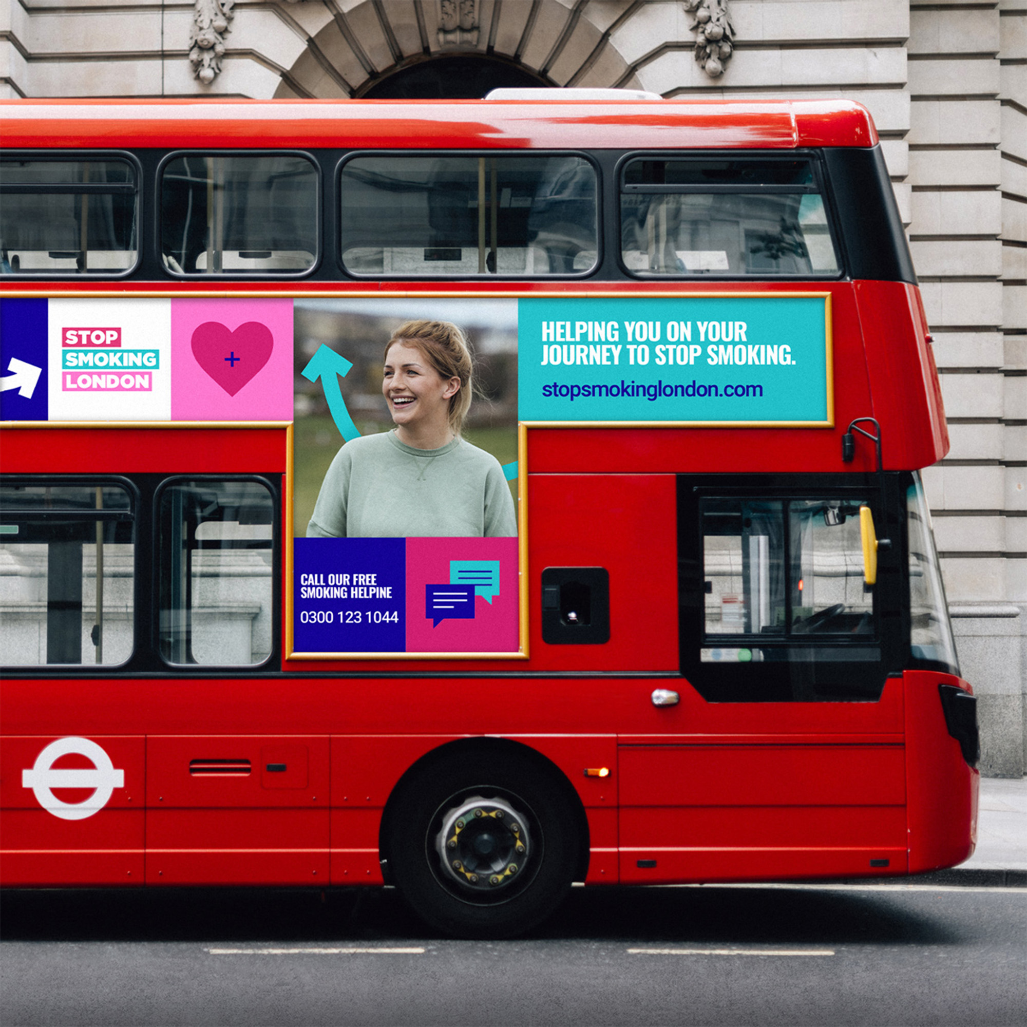 Double decker red bus in motion with bright advertising.