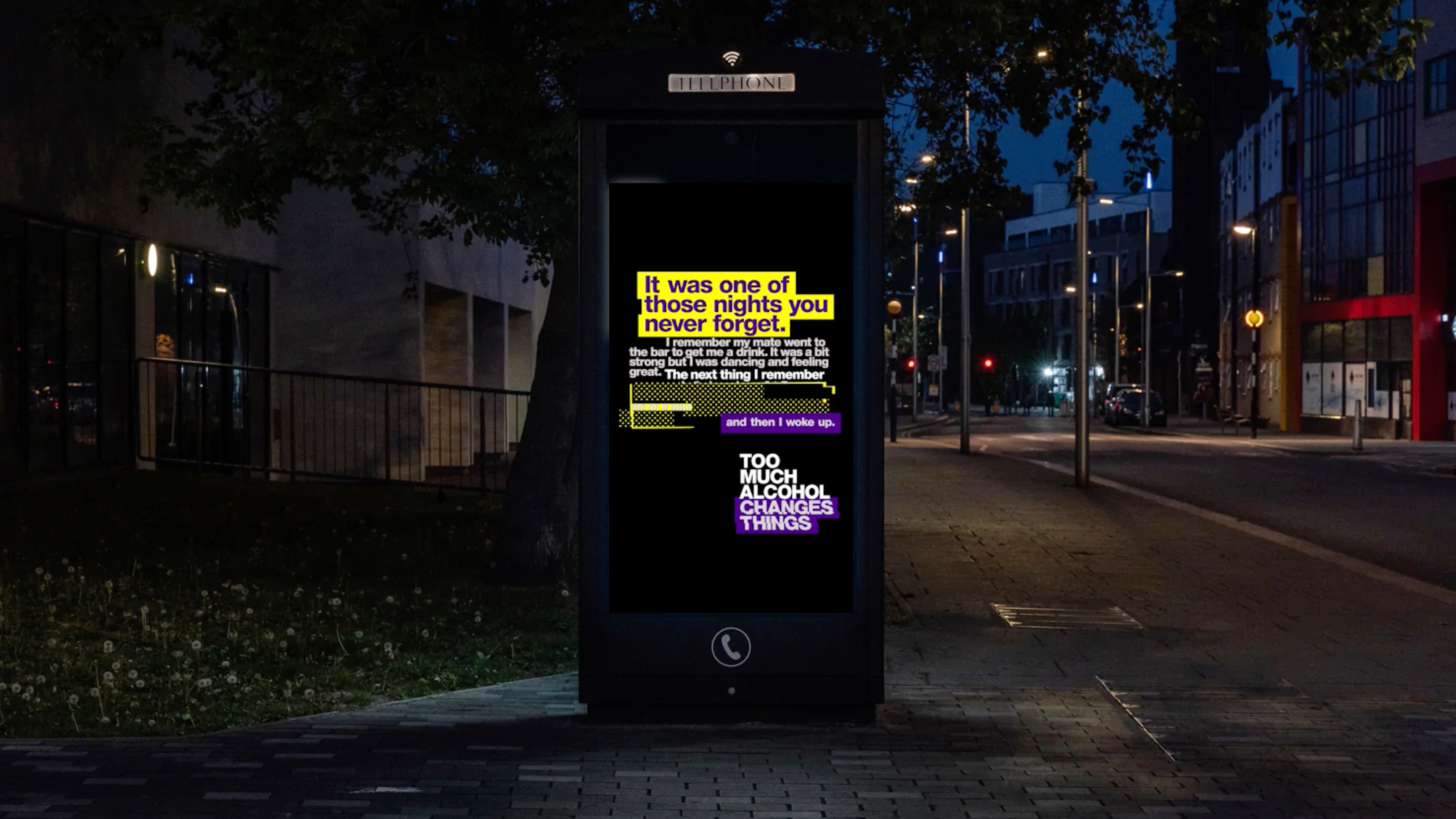 Telephone box with advertising lit up during nighttime.