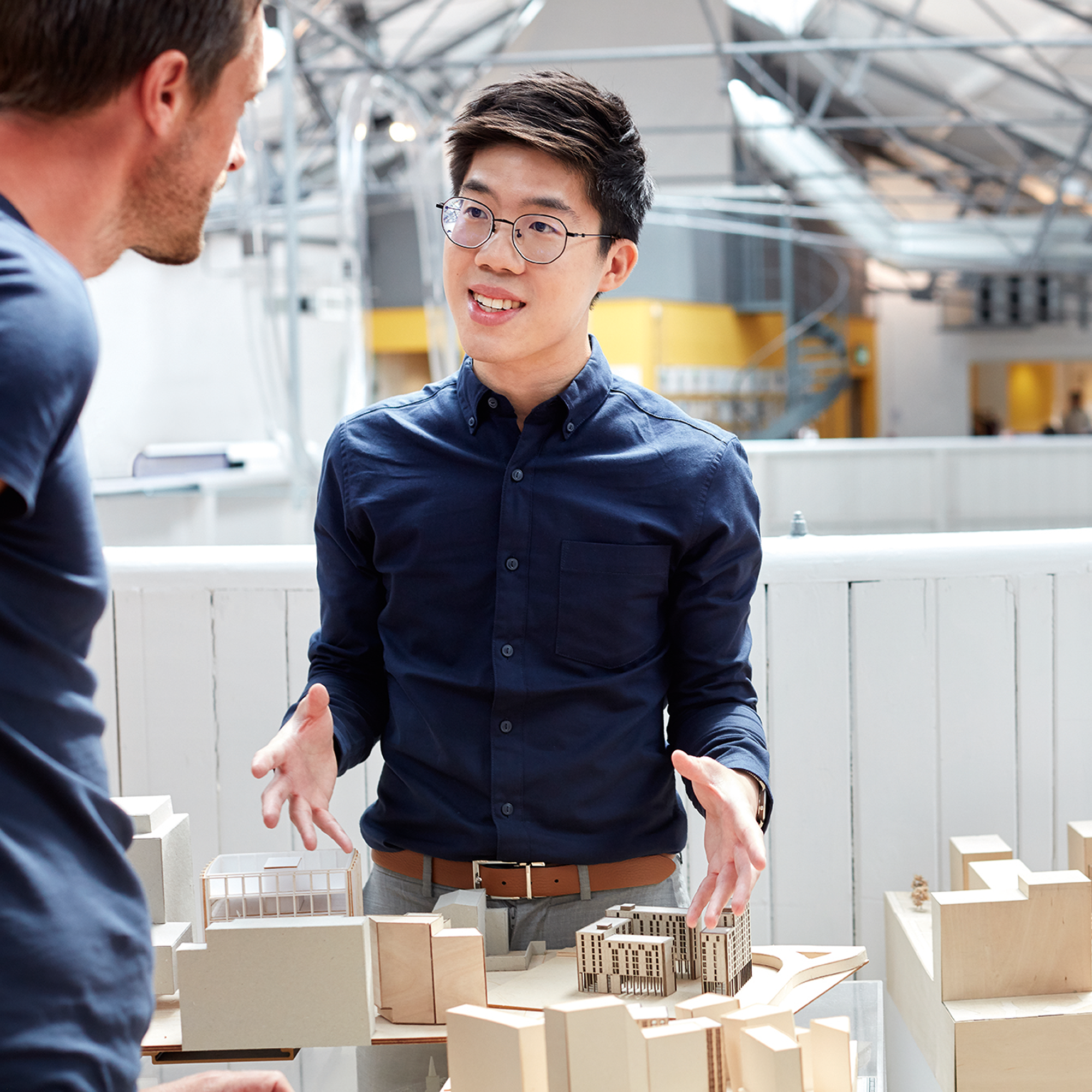 Person smiling and talking to another person in light, bright room.