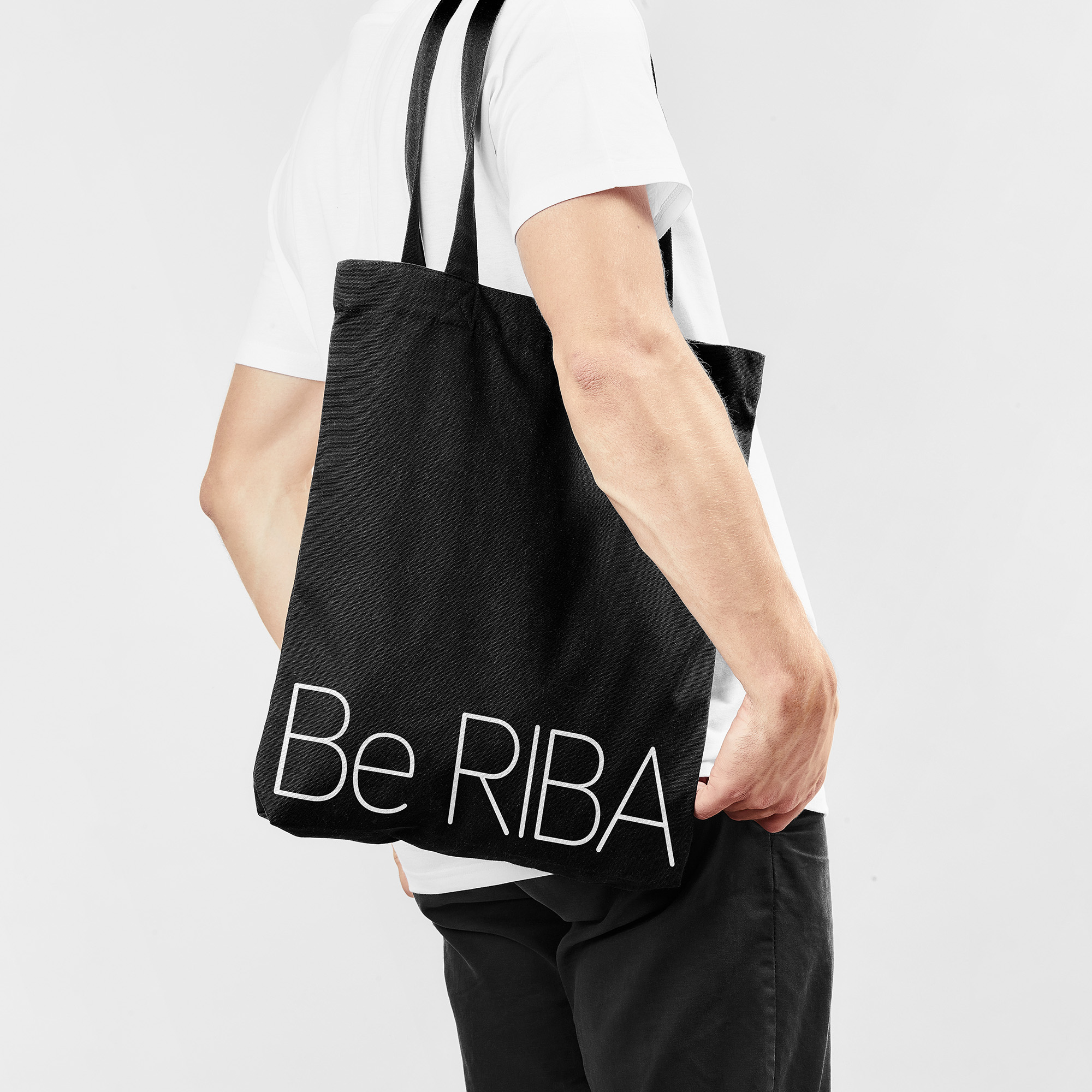 A person in a white t-shirt with a black tote bag