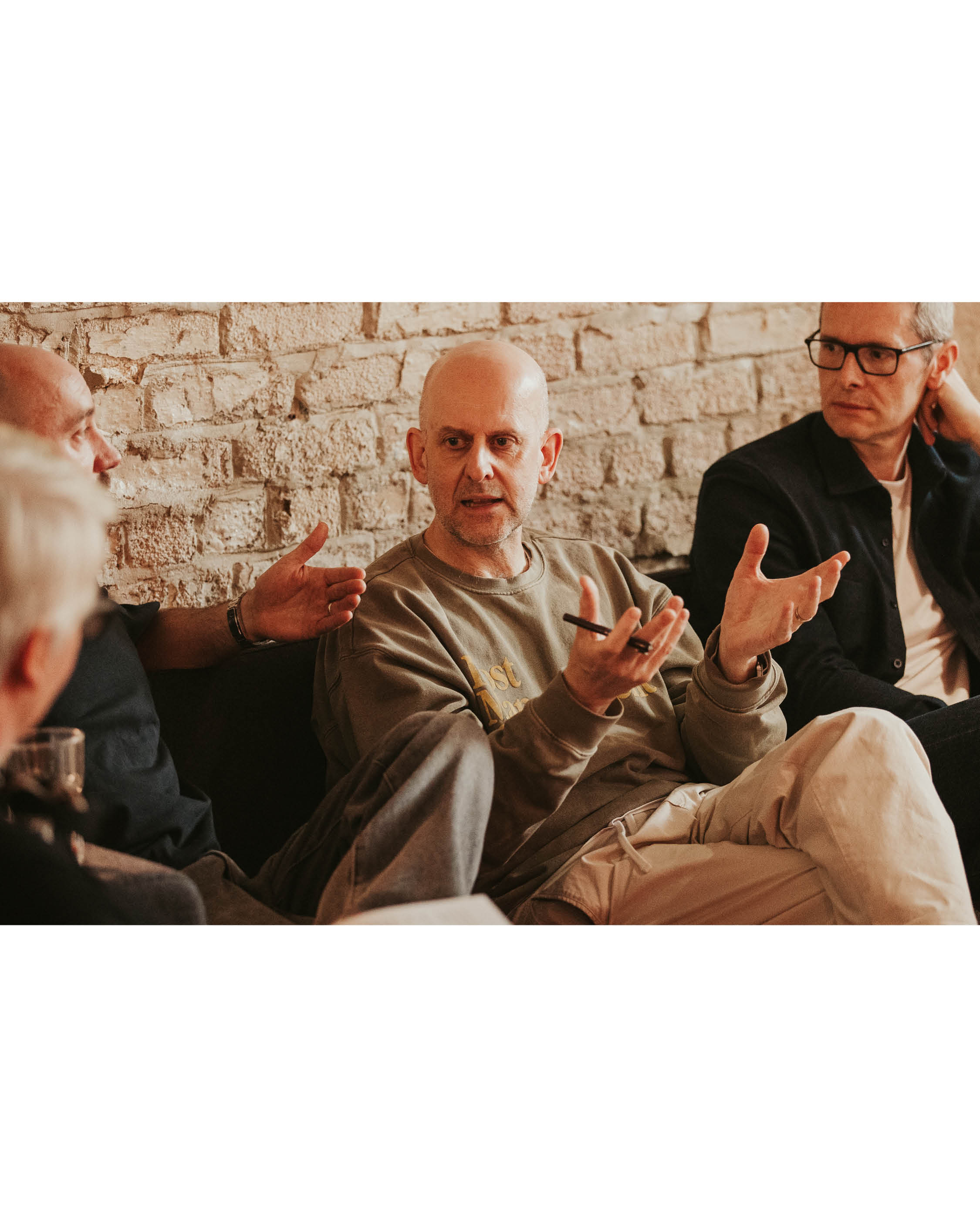 A man talking against a brick wall