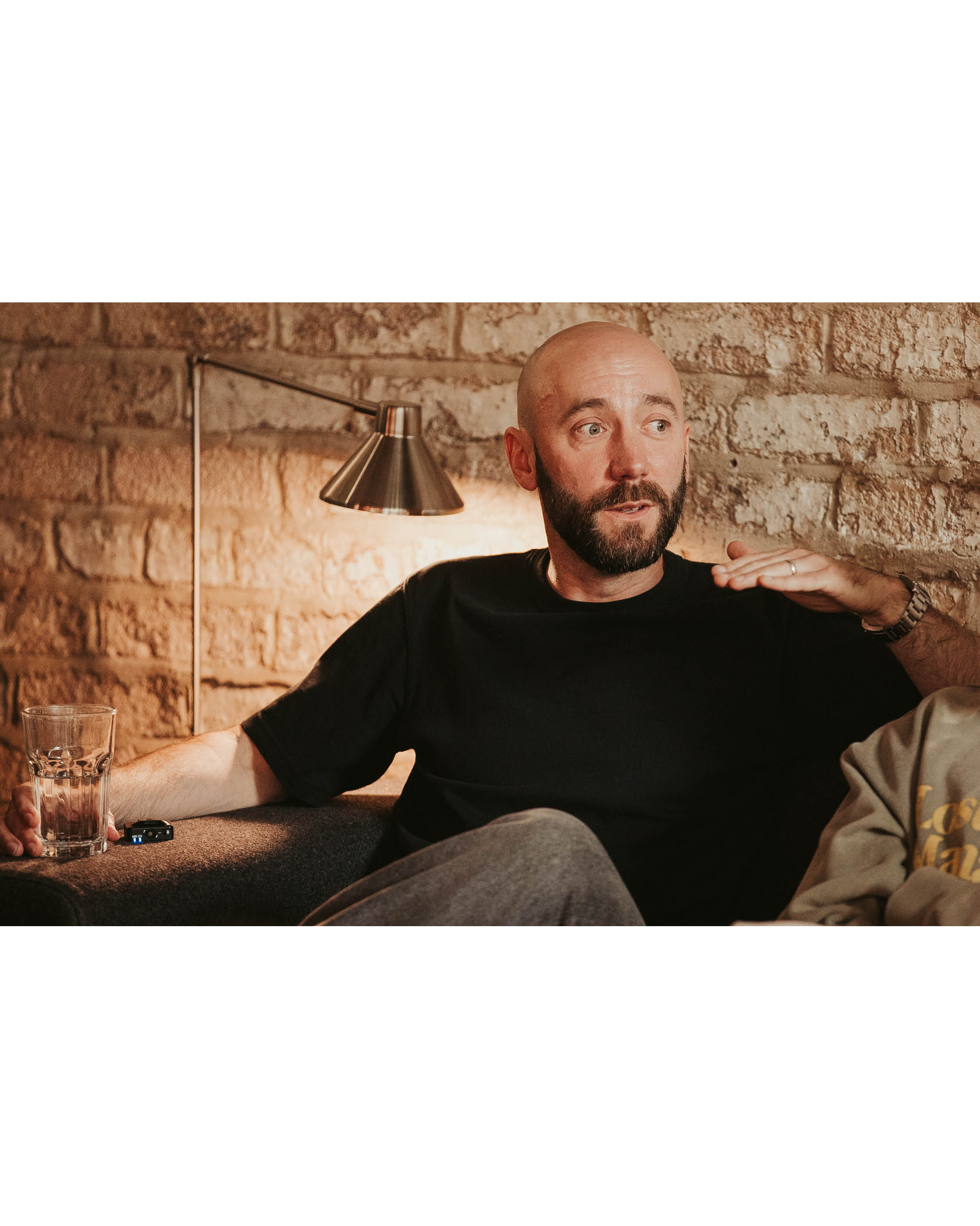 A man talking against a brick wall