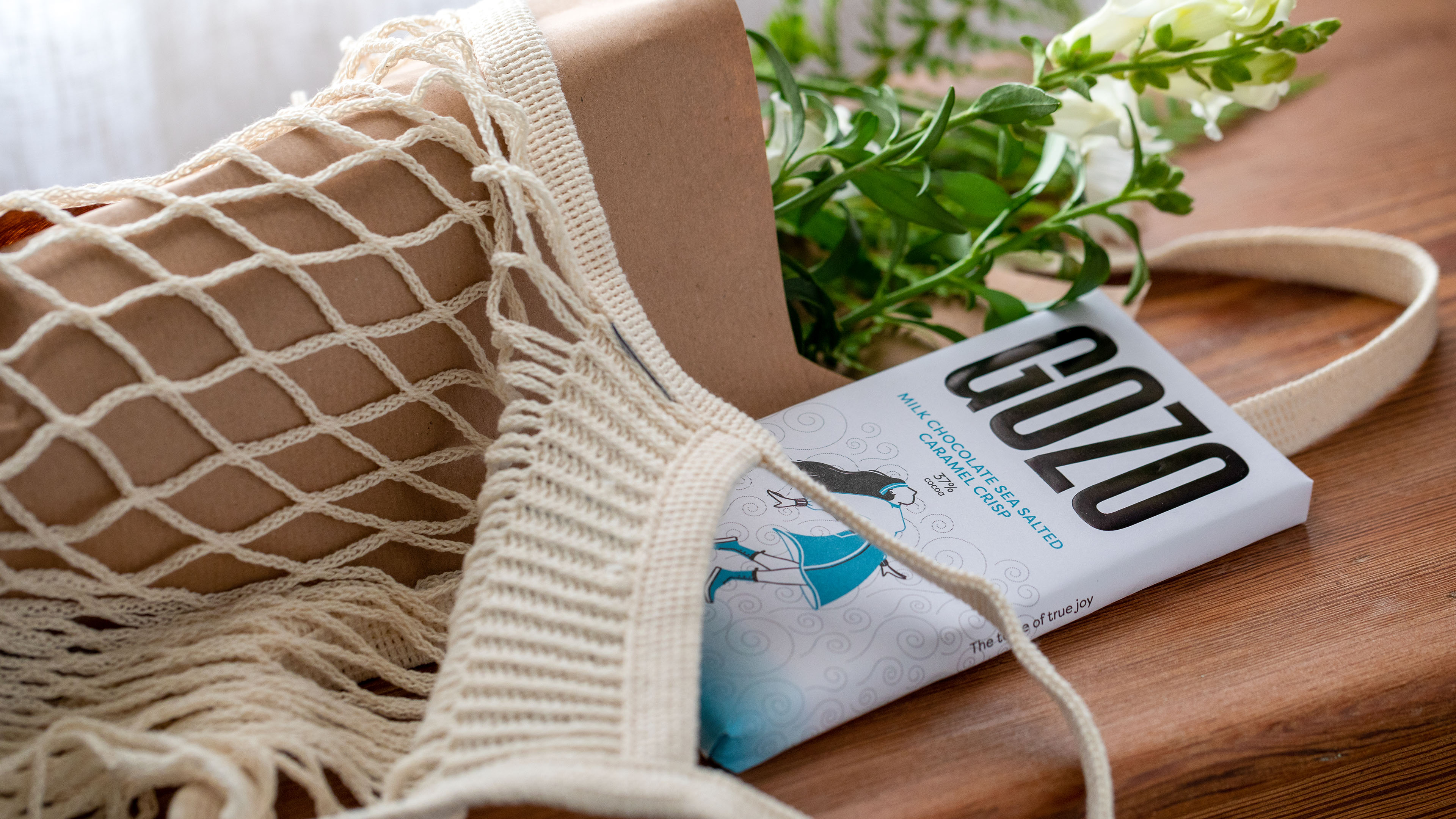 A blue chocolate bar spilling out of a bag onto a wooden table