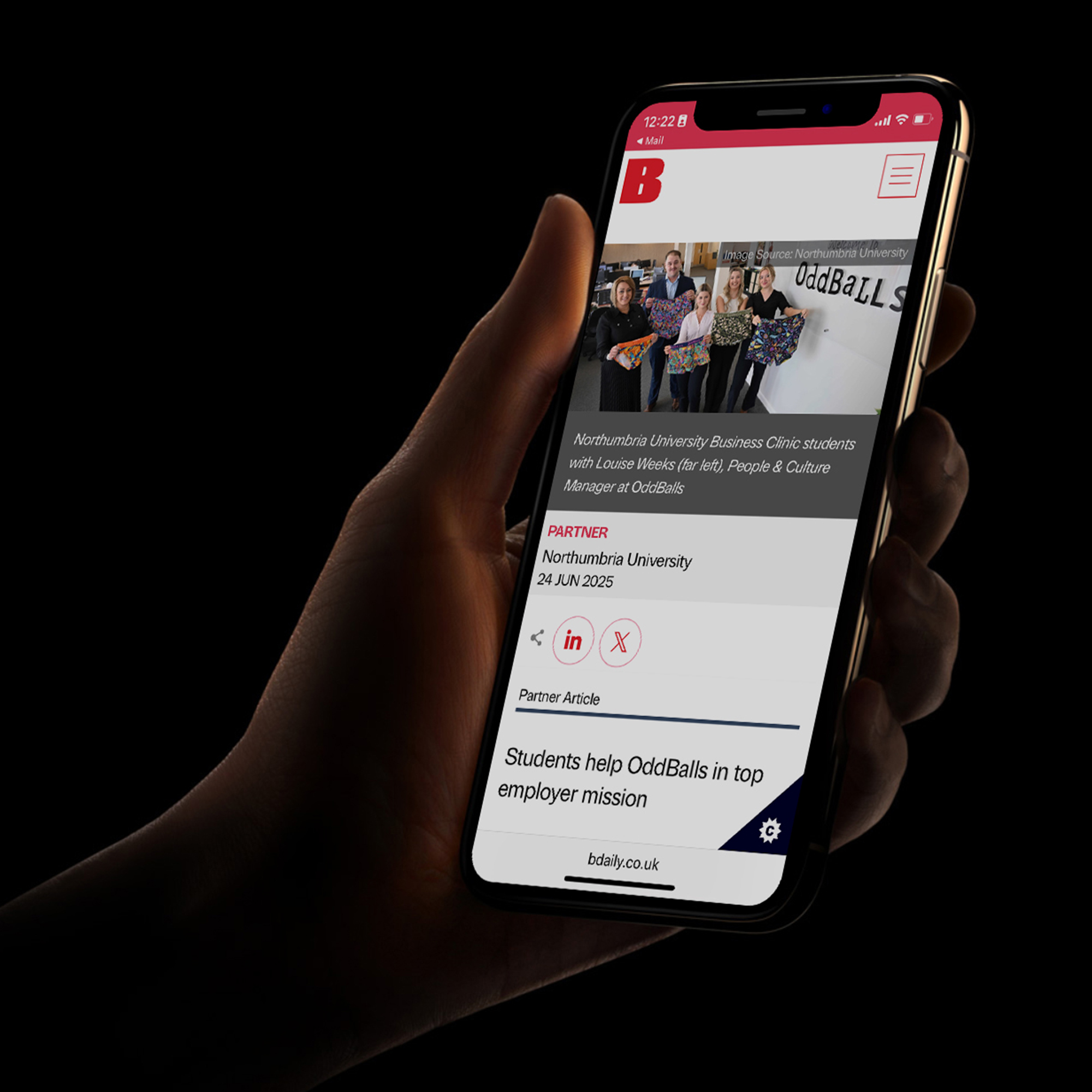 A hand holding a phone with a news article on screen.