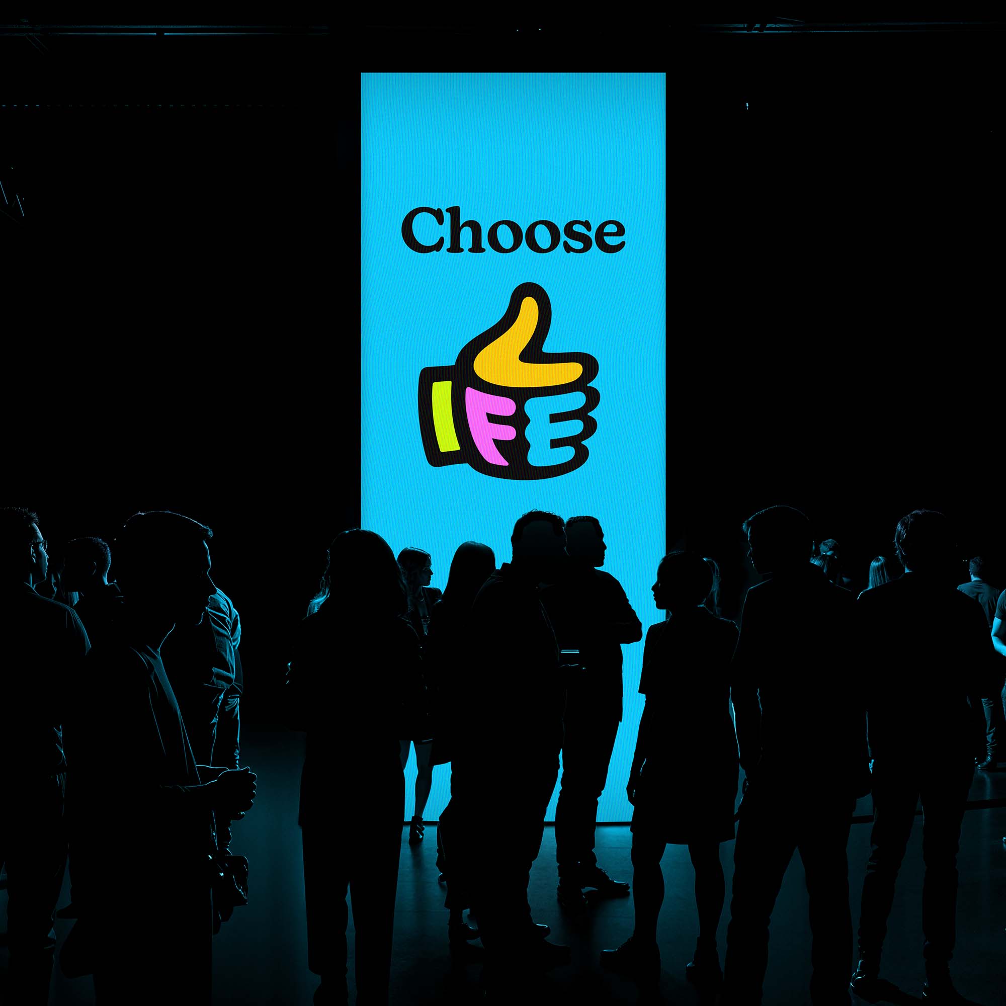 Large vertical digital screen which the message 'Choose Life' in front of a large group of people at conference event. The lettering in in bold black typeface and the 'Life' message in embodies in the the Life Factor logo.