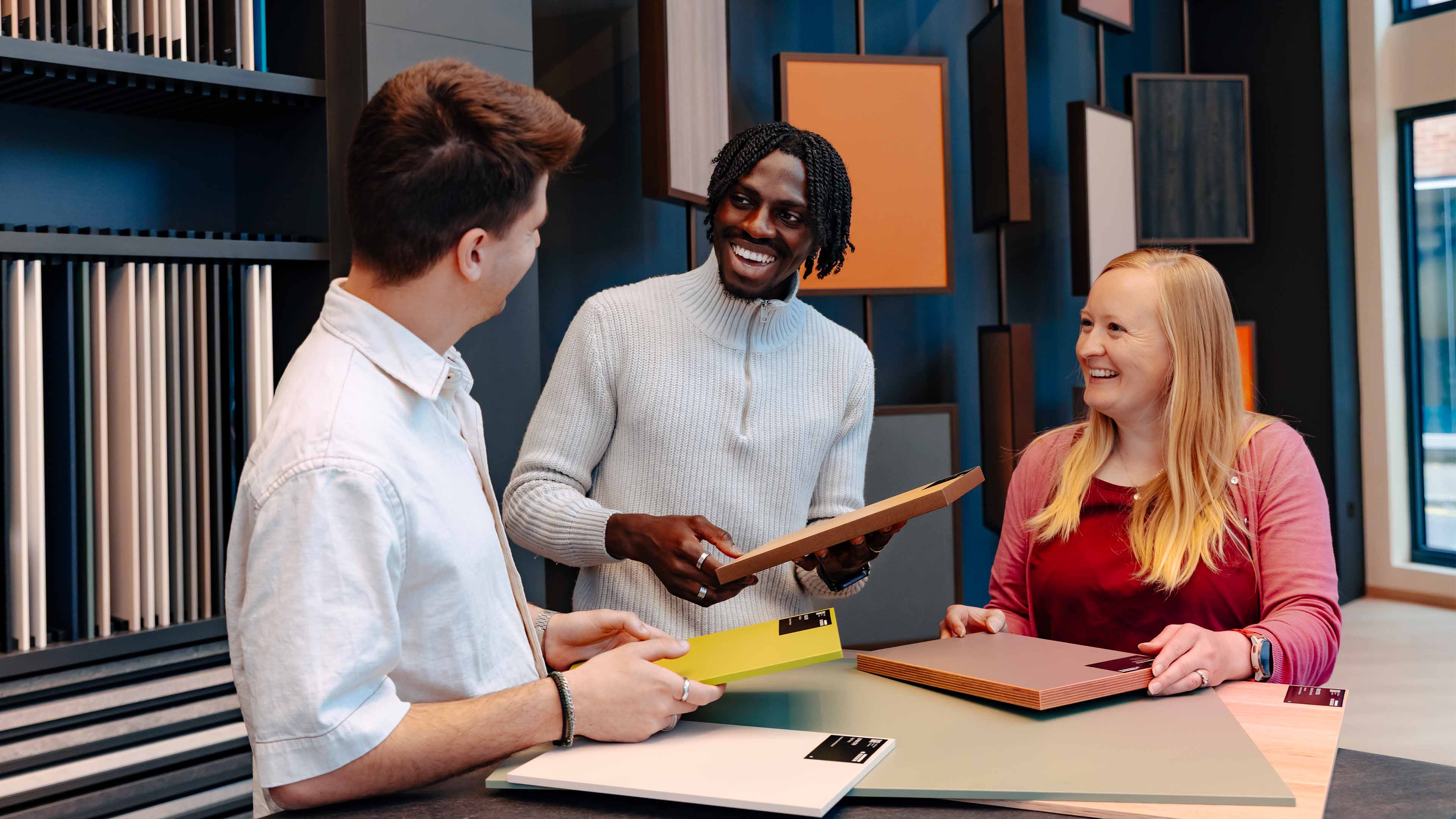 Group of people smiling looking at samples of material