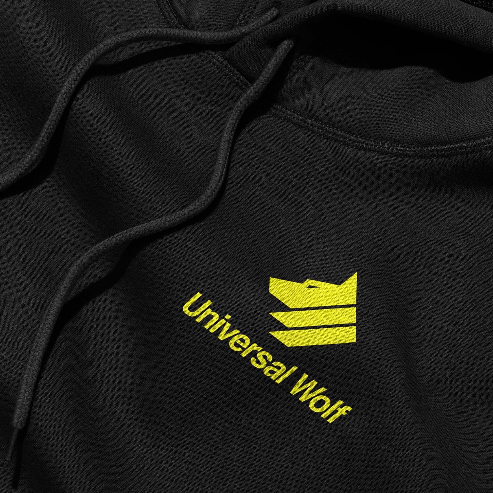 Detail of black hoodie with Universal Wolf logo in bright yellow on the chest area.
